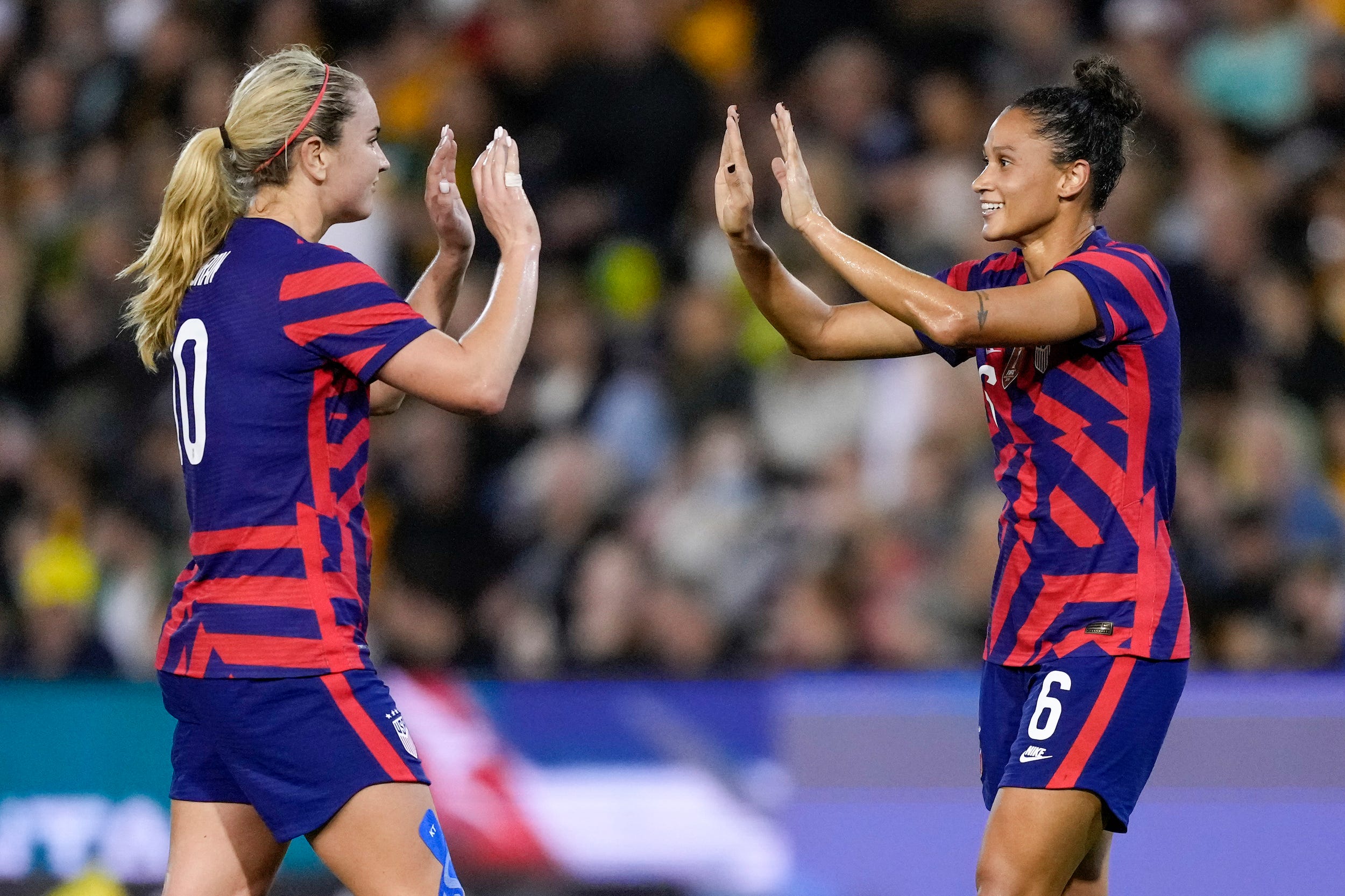 Lindsey Horan (left) and Lynn Williams high five during a USWNT game against Australia.