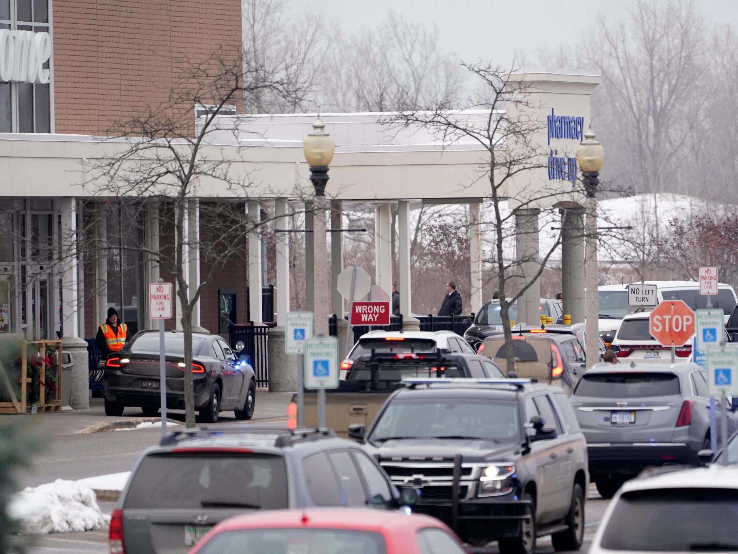 Police stand outside a store where Oxford high school students gathered following a shooting.