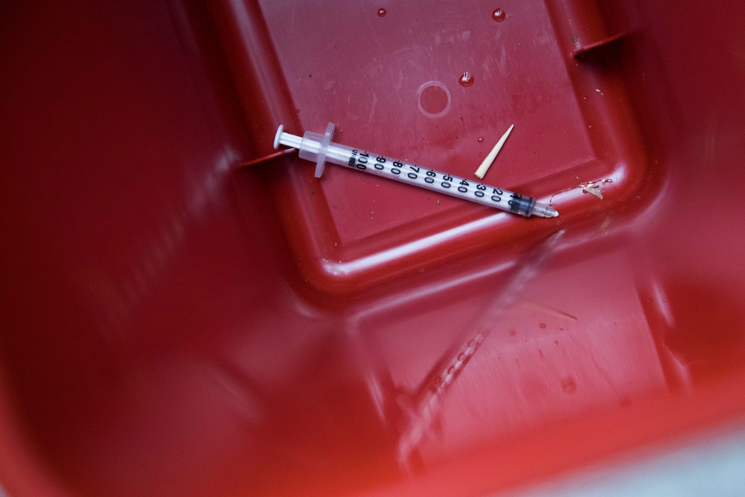 used syringe in disposal container