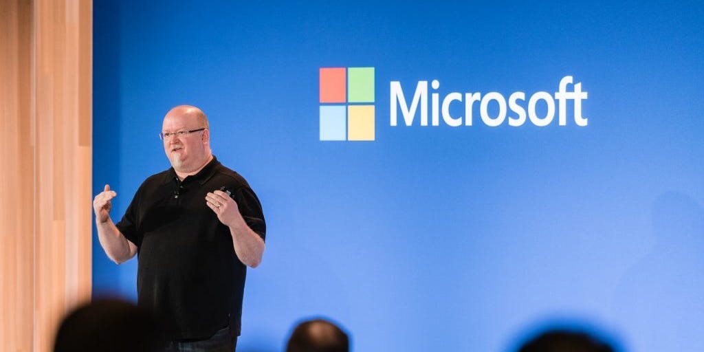 Microsoft CTO Kevin Scott speaks on stage in front of a Microsoft logo.