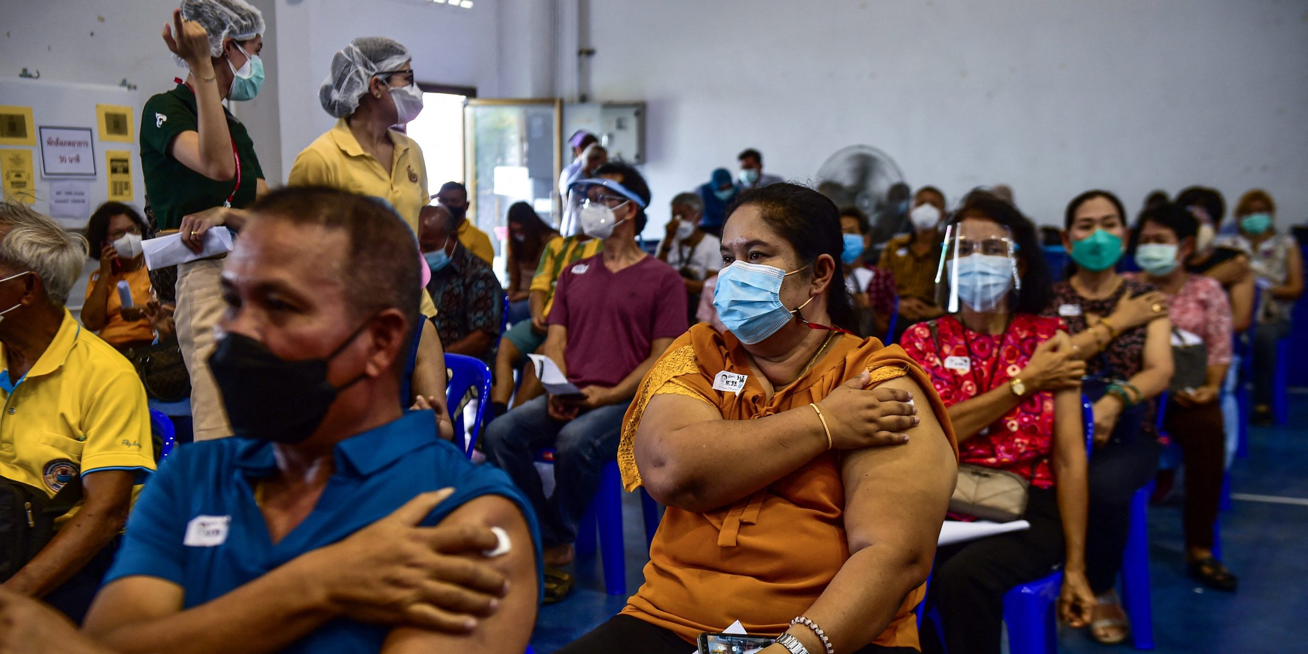 People hold their plaster patches after being administered doses of the AstraZeneca Covid-19 coronavirus vaccine at the Narathiwat Hospital compound in the southern province of Narathiwat on June 7, 2021, as mass vaccination rollouts begin in Thailand.