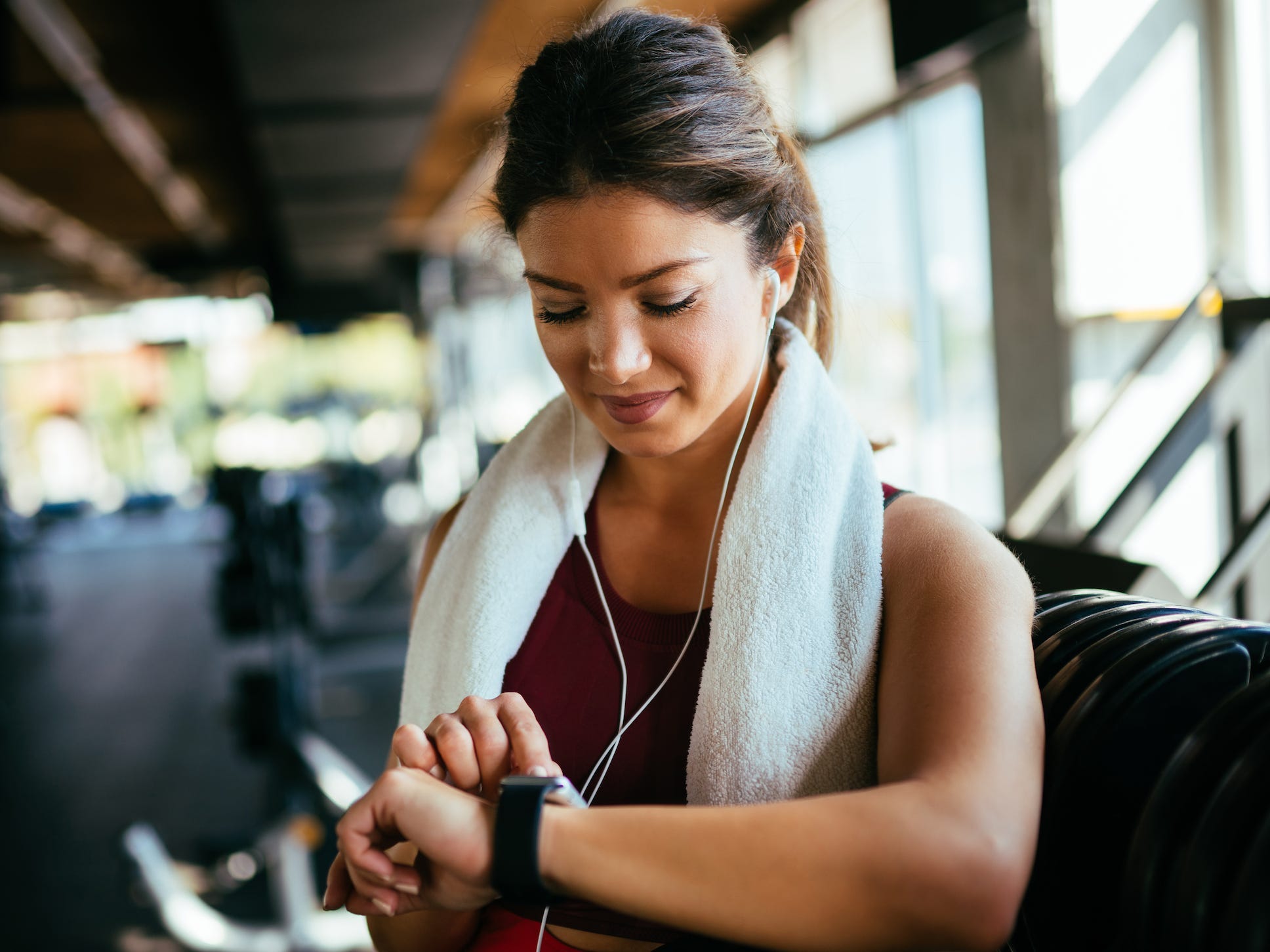 woman exercising in gym looking at smart watch