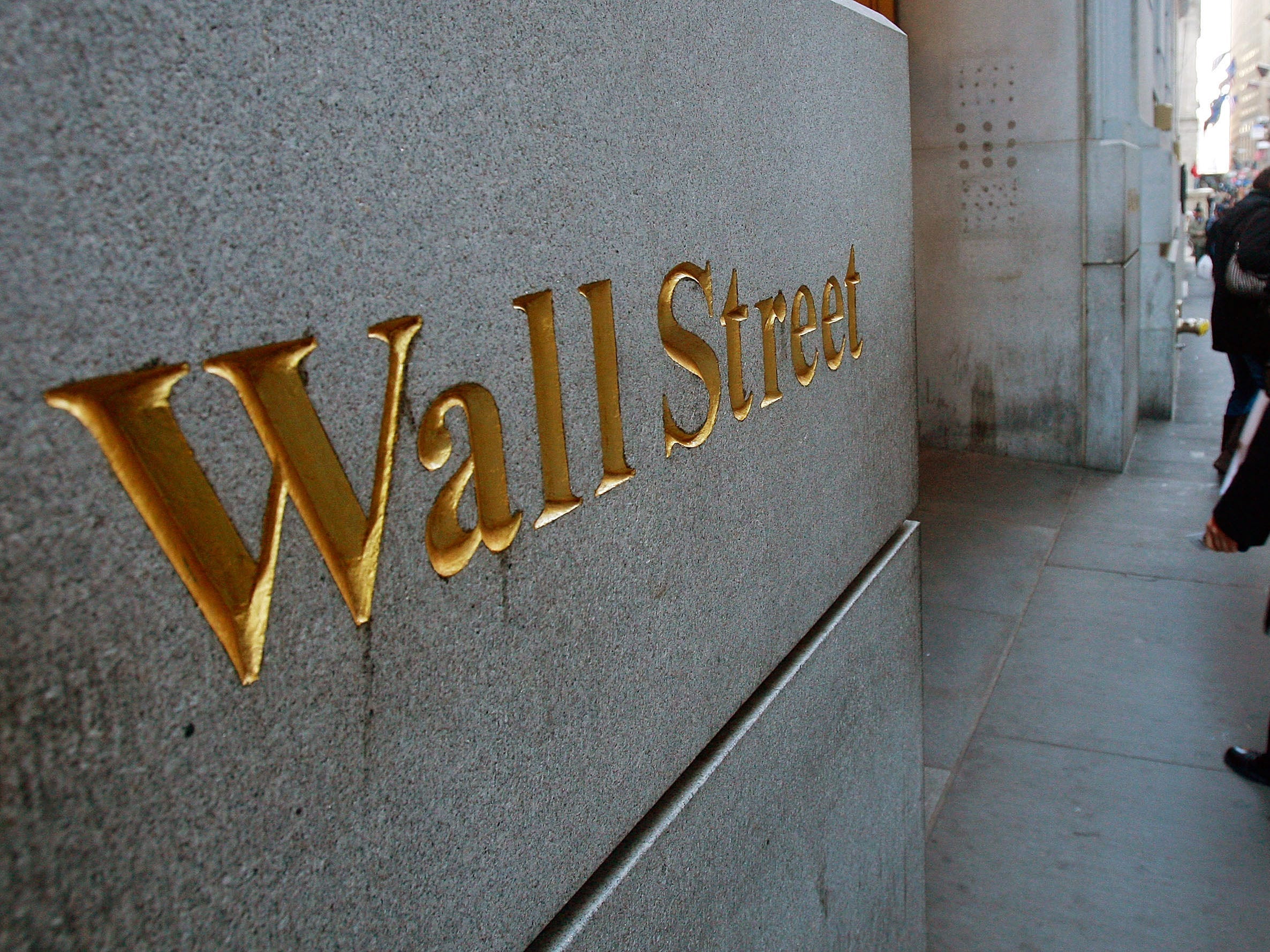 wall street man walking into building nyse stock exchange