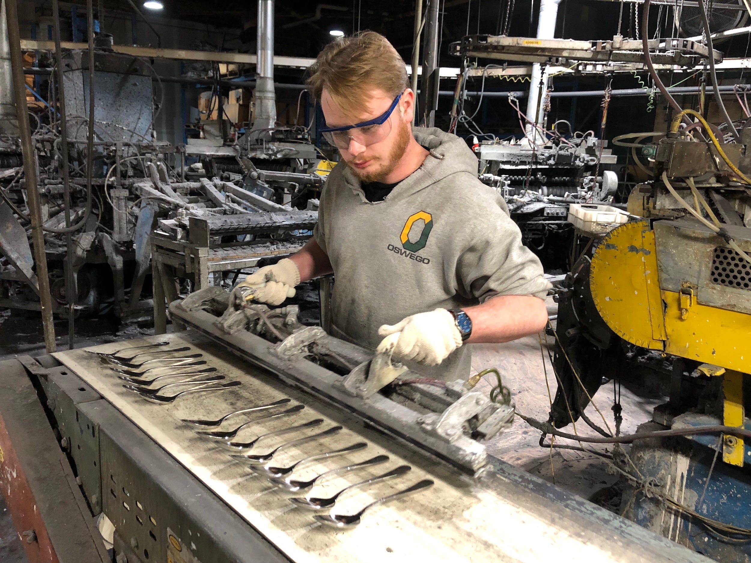 Man works machine making spoons at Sherrill Manufacturing