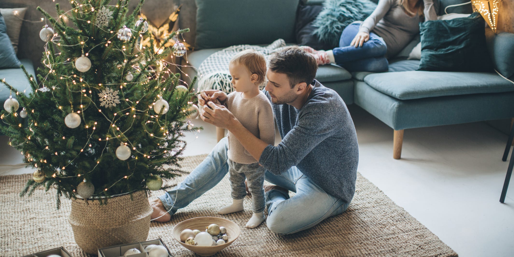 A father and child decorating a small Christmas tree