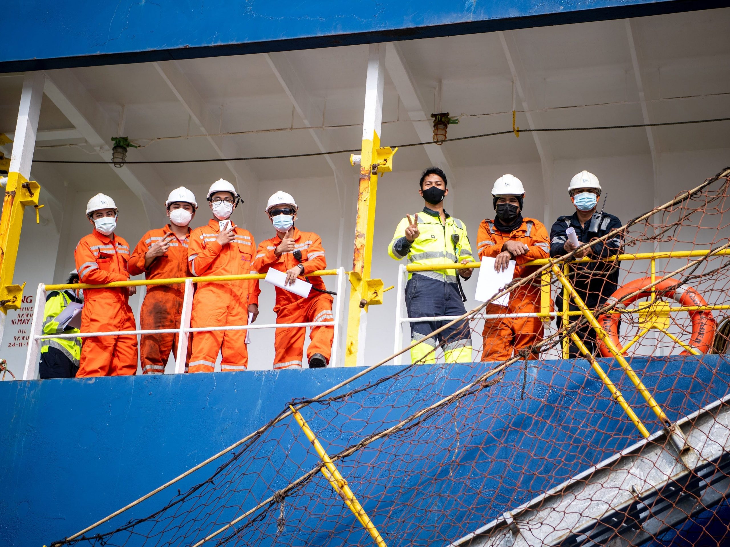 Seafarers with face masks on board a ship.