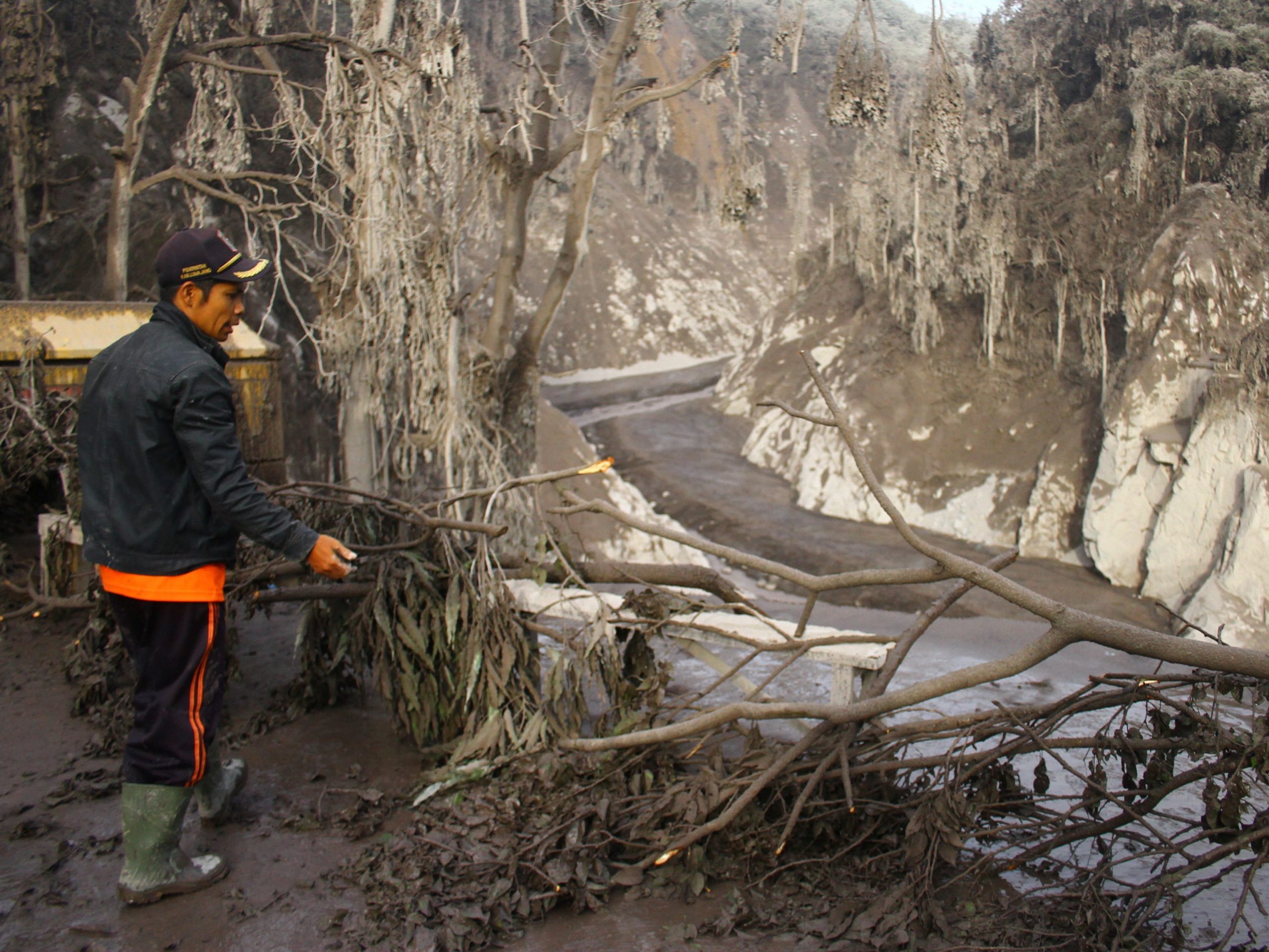 An Indonesian rescue officer stands near a broken bridge that was hit by the eruption of Mount Semeru in Candipuro village, Lumajang, Indonesia December 5, 2021,