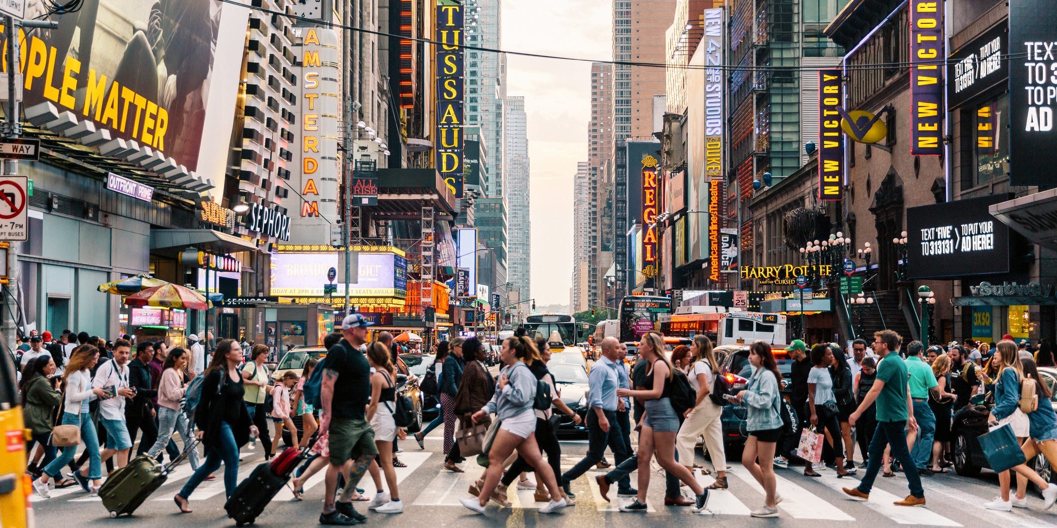 Crowds of people crossing street on zebra crossing in New York, USA