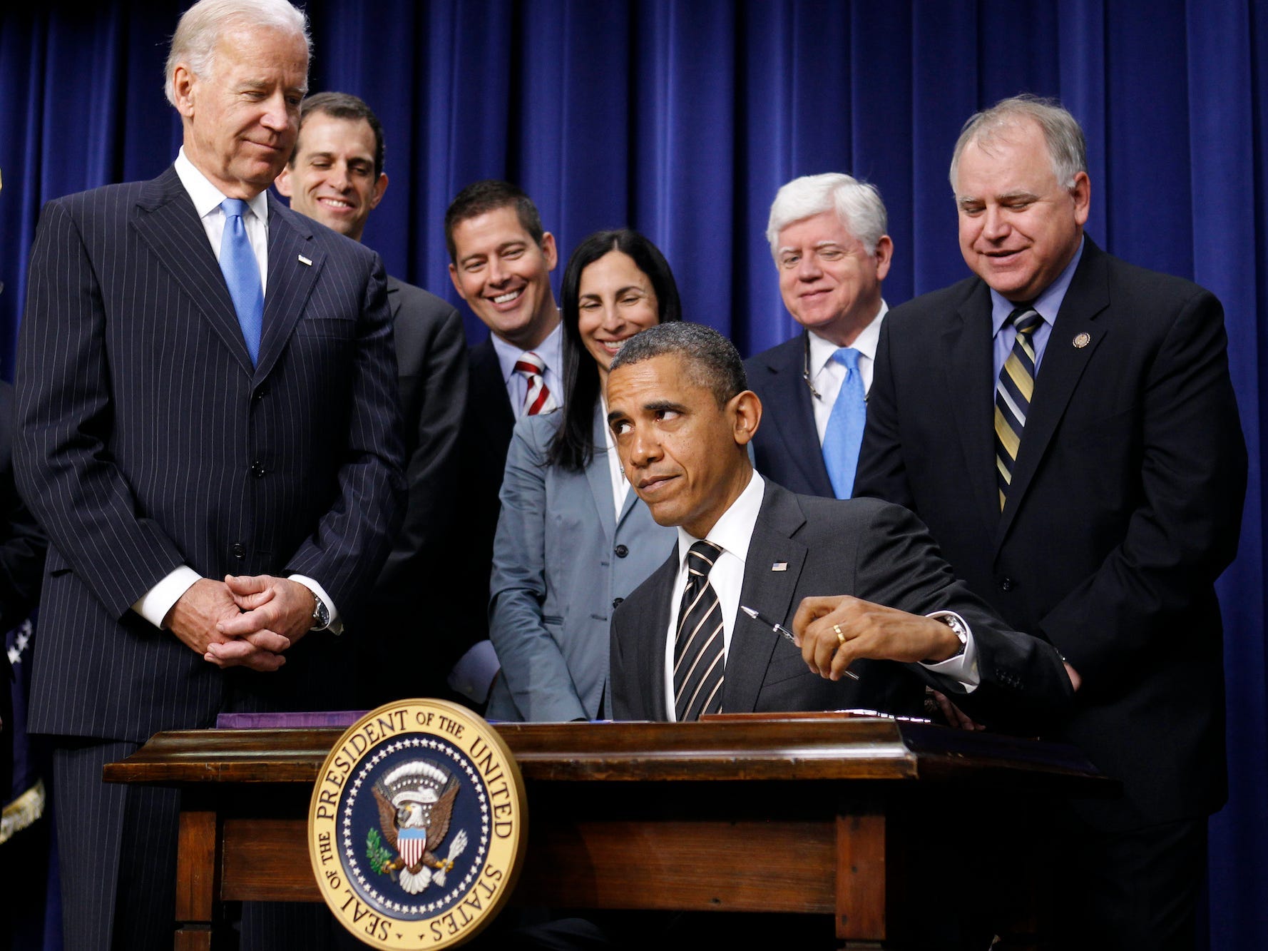 President Barack Obama, joined by Vice President Joe Biden and lawmakers, signs the Stop Trading on Congressional Knowledge (STOCK) Act, Wednesday, April 4, 2012, in the Eisenhower Executive Office Building on the White House complex in Washington.