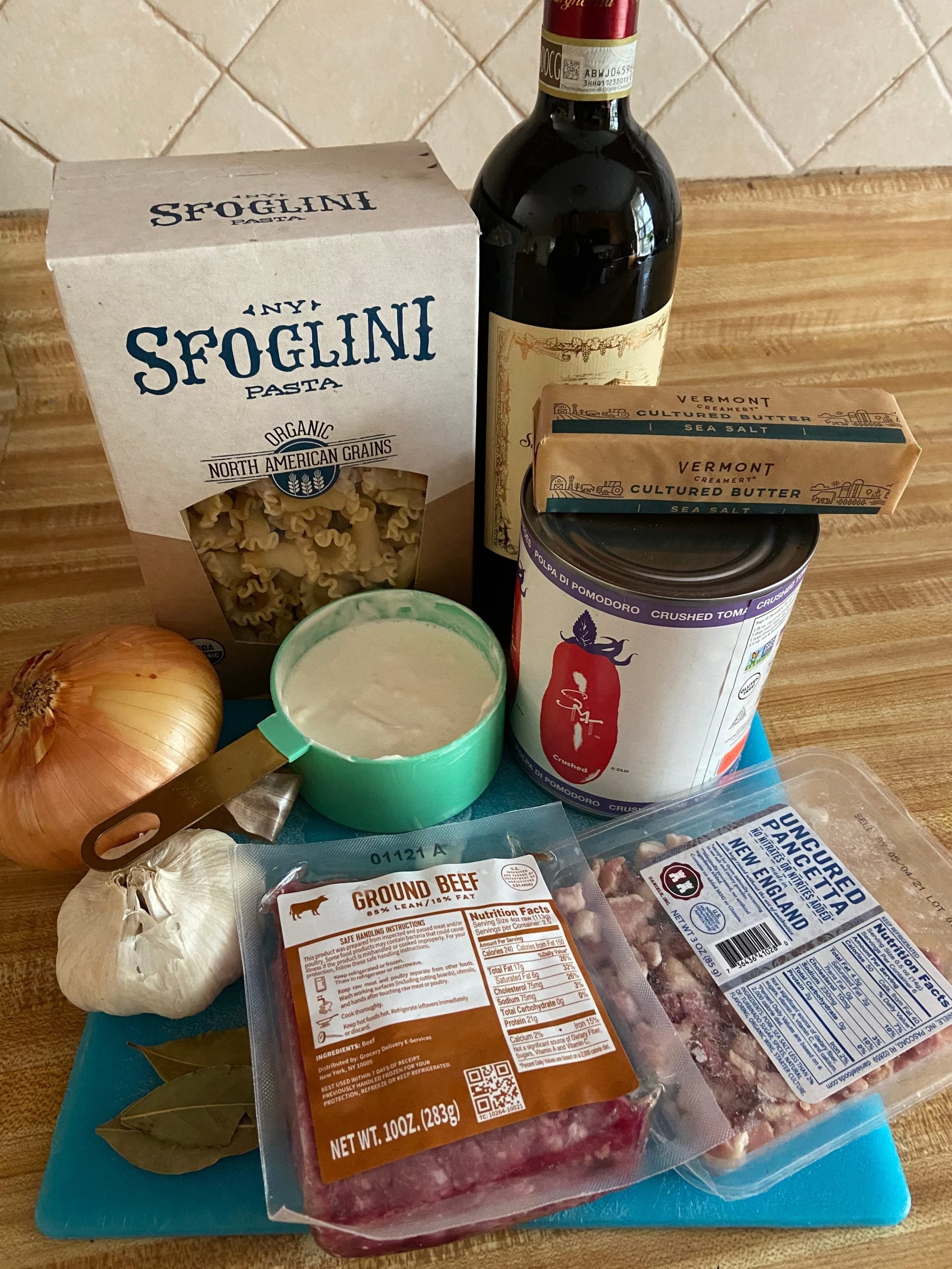 ingredients for a bolognese sauce laid out on a kitchen counter