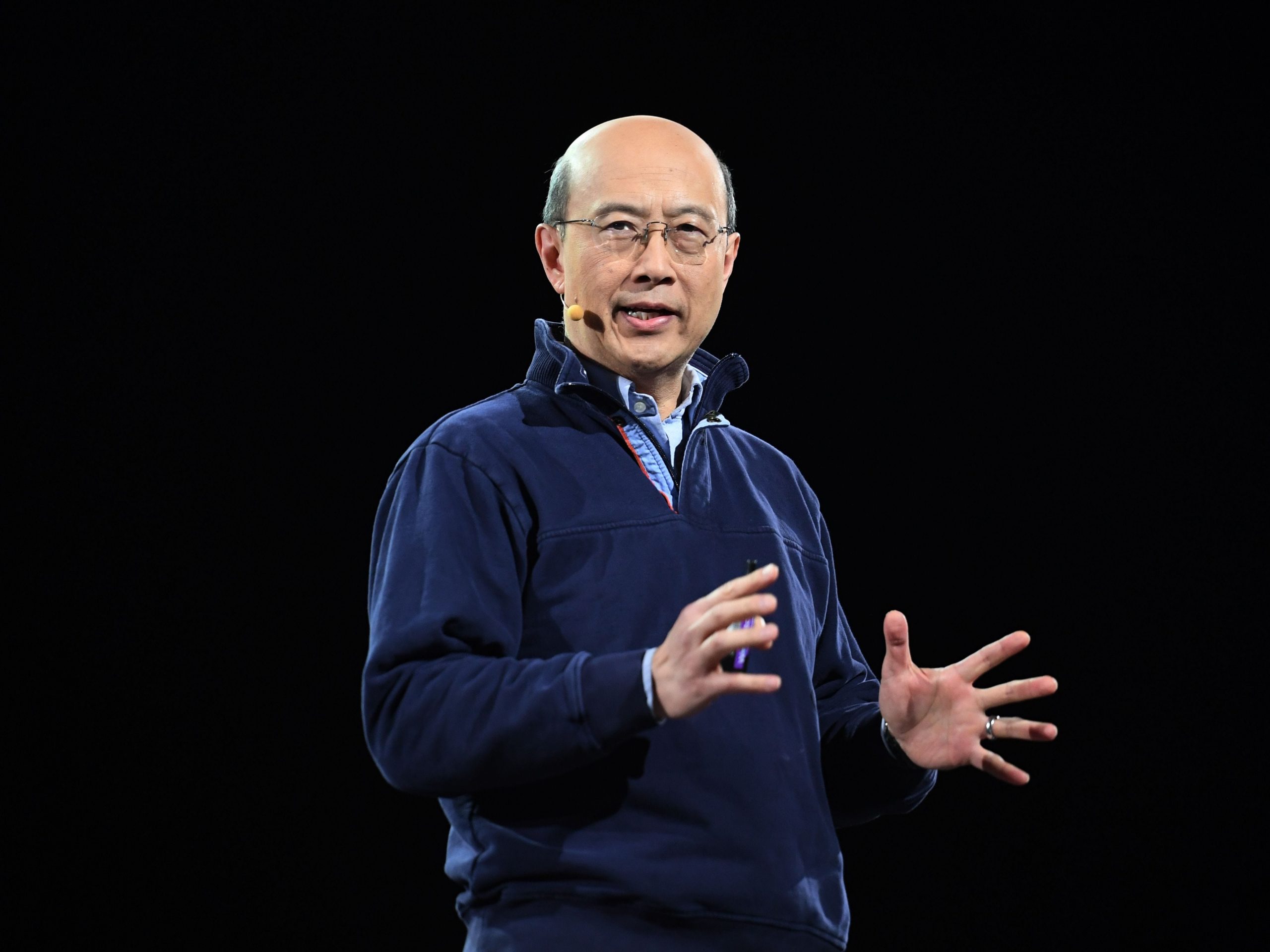 MIT professor Andrew Lo presents on stage during an artificial intelligence and robotics conference.
