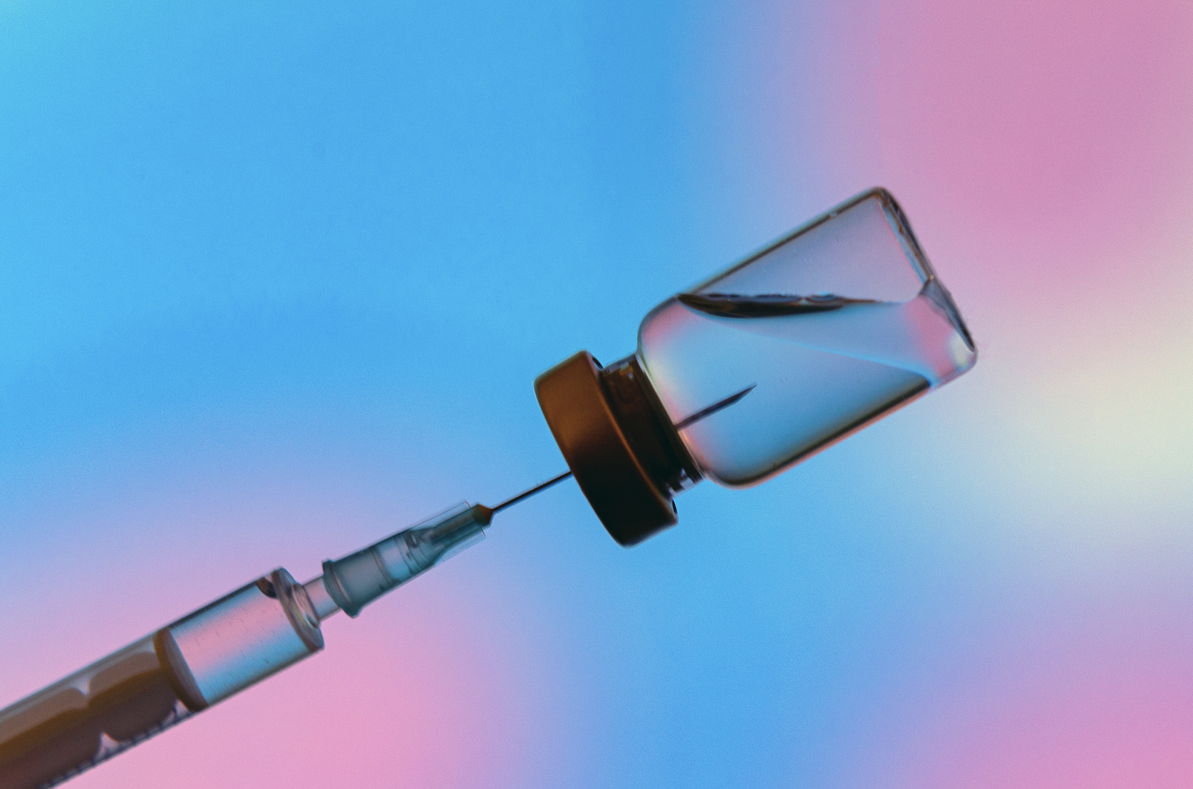 Injection vial with syringe needle on blue and purple background.