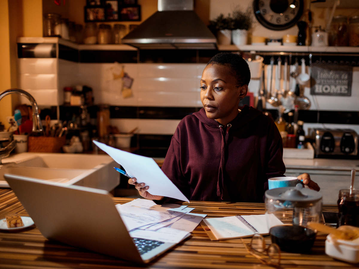 Young woman doing home finances in her kitchen.