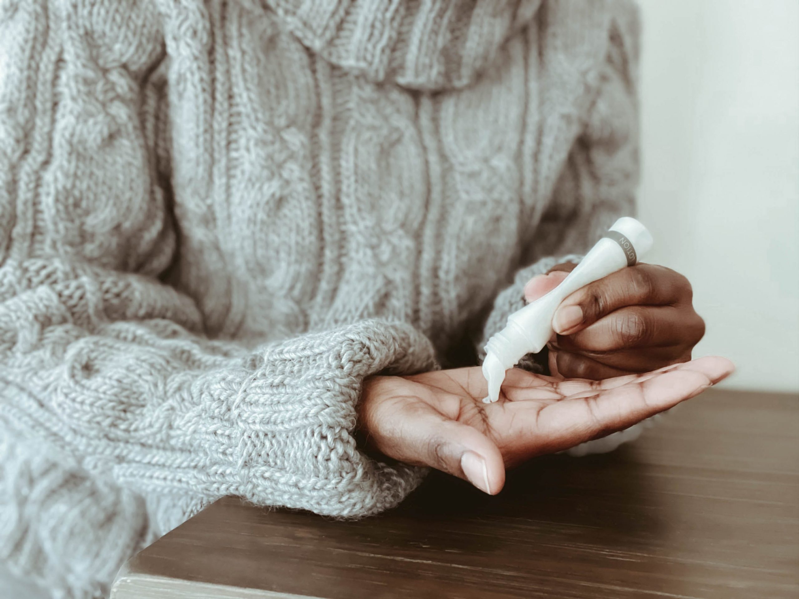 woman applies moisturizer to hands