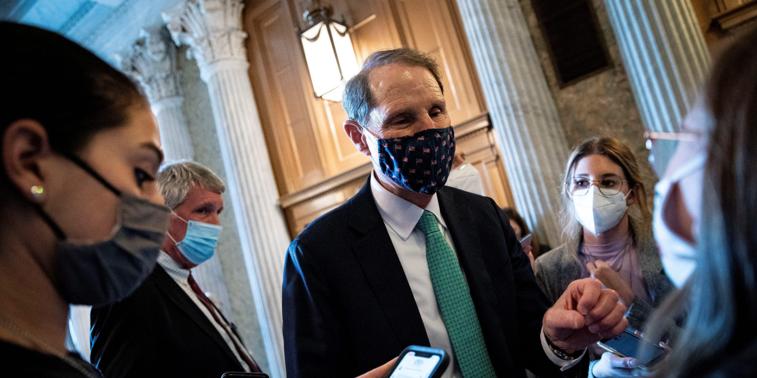 Senator Ron Wyden wears a mask and speaks to reporters in the US Capitol