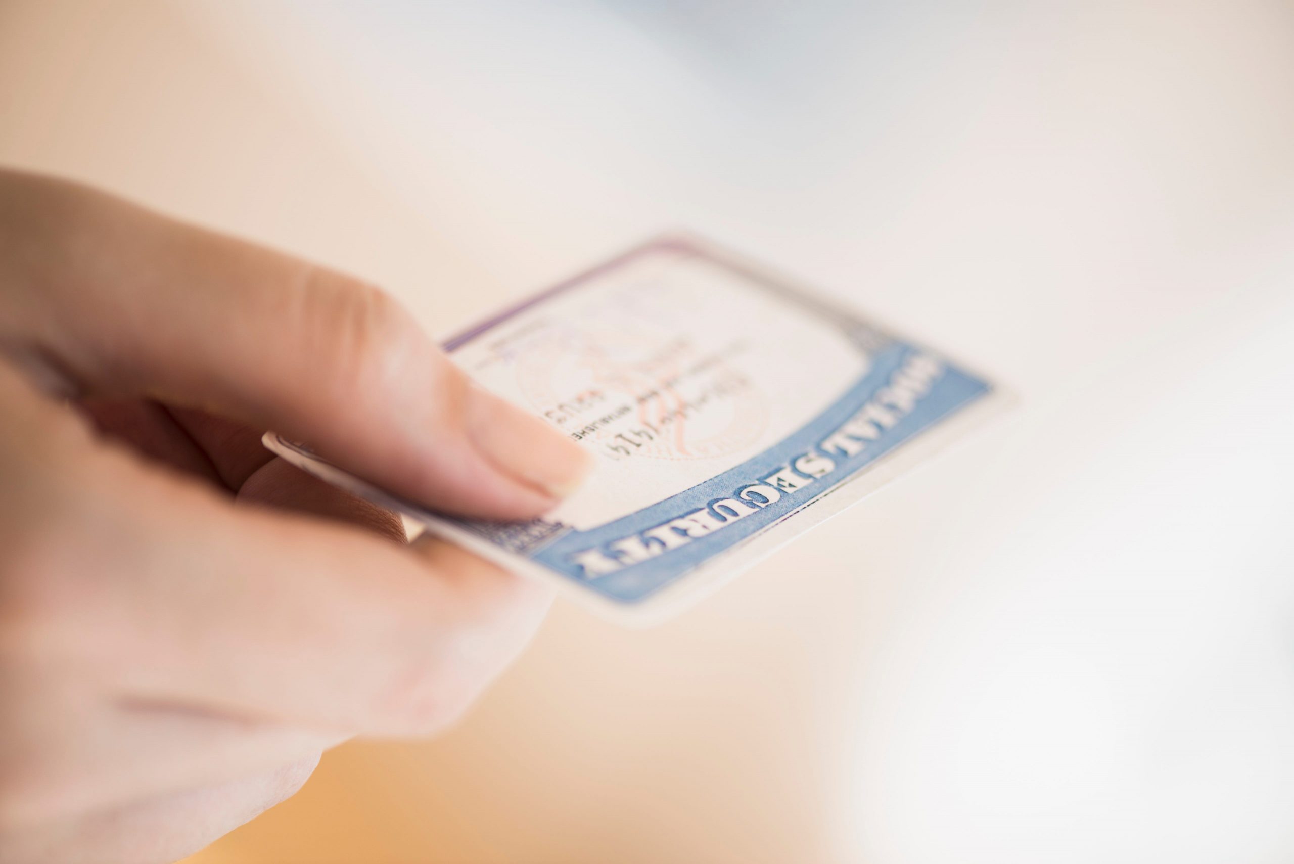 A hand holds a social security card