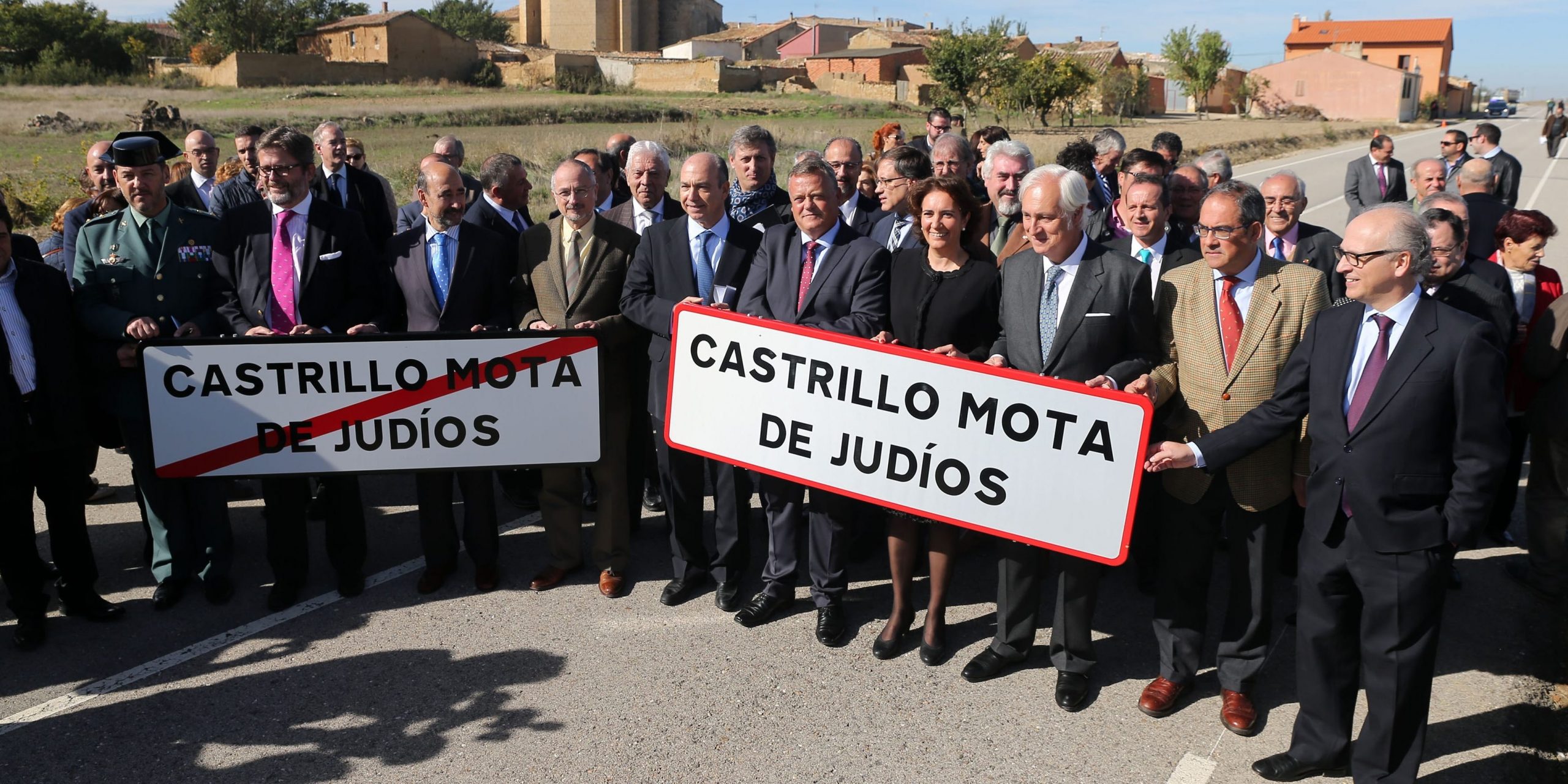 Officials look at an employee setting up a road sign reading the new name of Spanish village "Castrillo Mota de Judios" which means "Castrillo Mound of Jews" at the entrance of Castrillo Mota de Judios, near Burgos on October 23, 2015