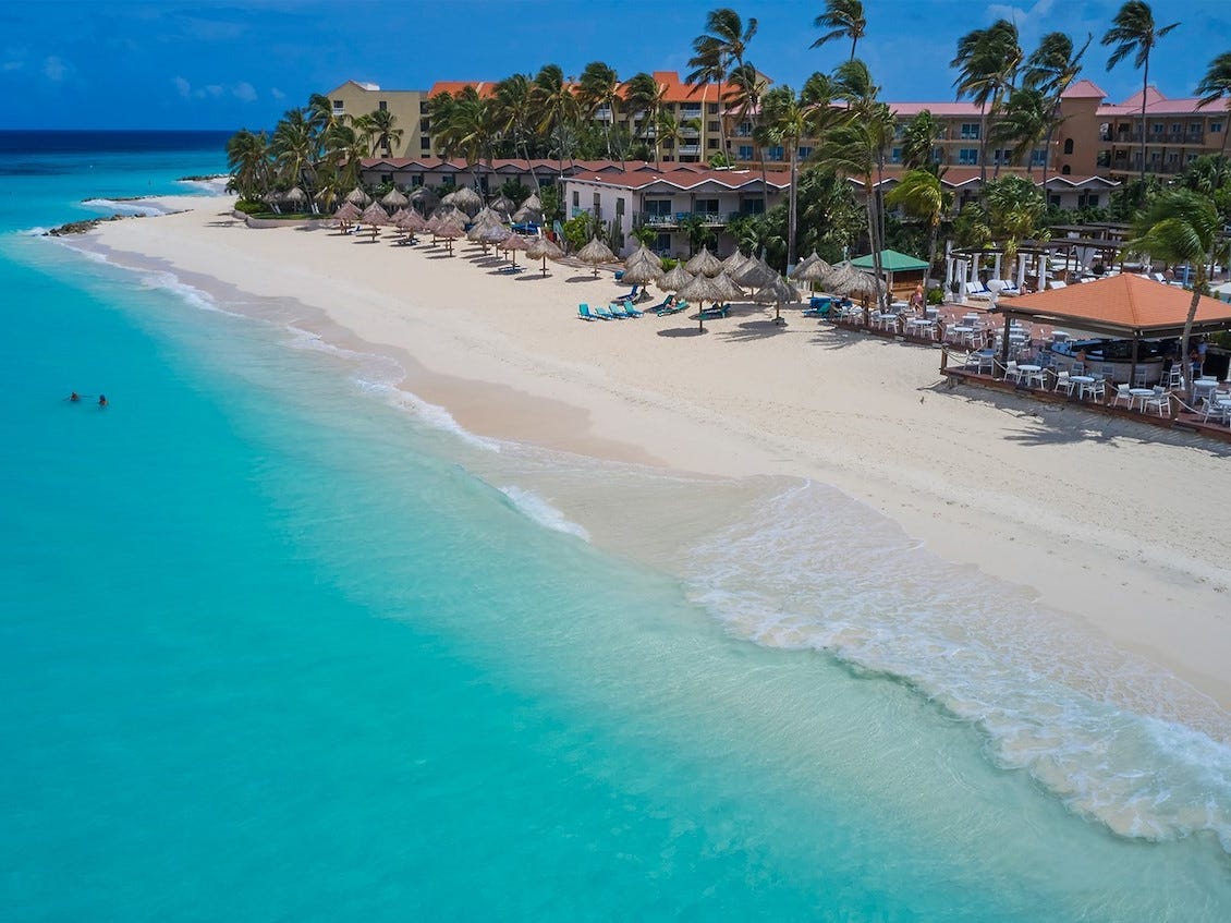 A view of the beach and hotel at Divi Beach All Inclusive in Aruba.