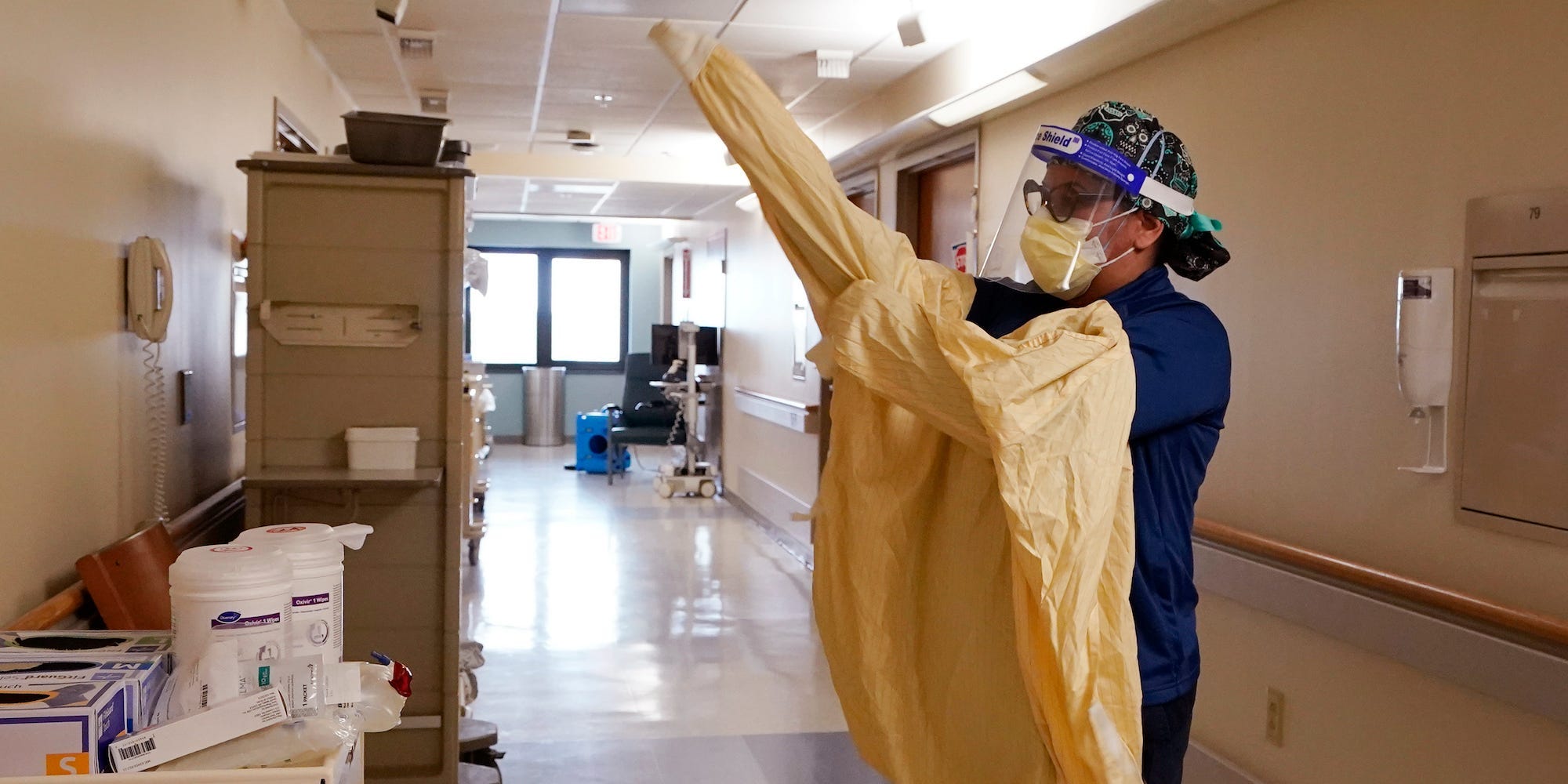 Registered Nurse Monica Quintana dons protective gear before entering a room at the William Beaumont hospital, April 21, 2021 in Royal Oak, Mich.