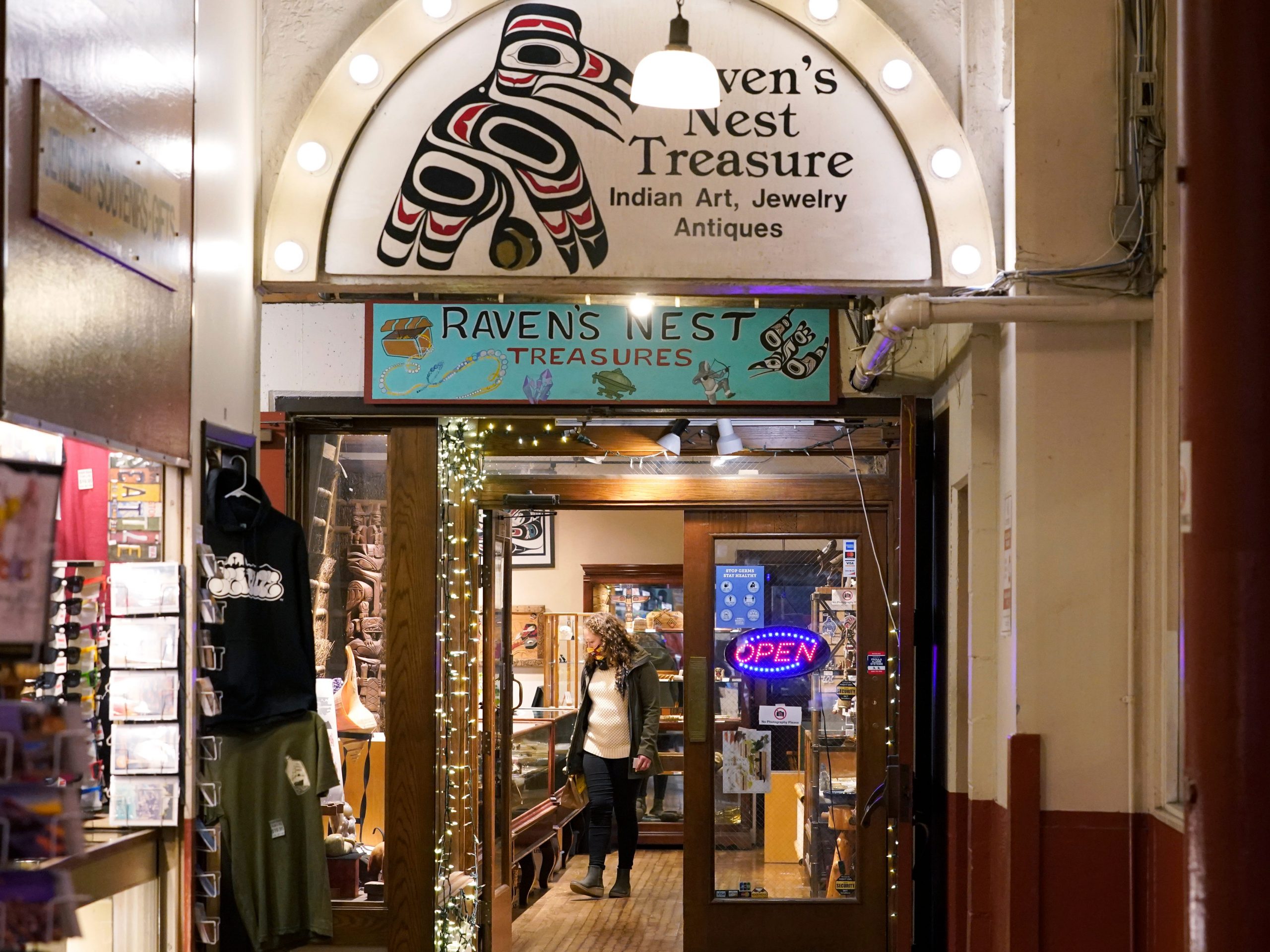 A person browses offerings in the Raven's Nest Treasure shop in Pike Place Market, Friday, Dec. 10, 2021, in Seattle.