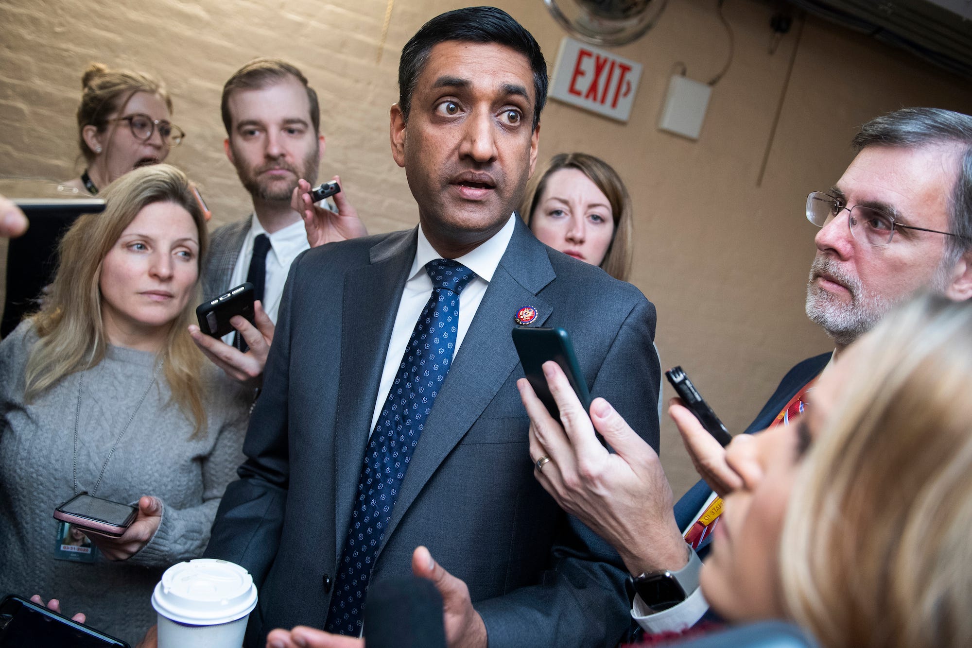Rep. Ro Khanna, wearing a dark suit, answers questions from the crowd of reporters gathered all around him in one of the many tunnels beneath the US Capitol.
