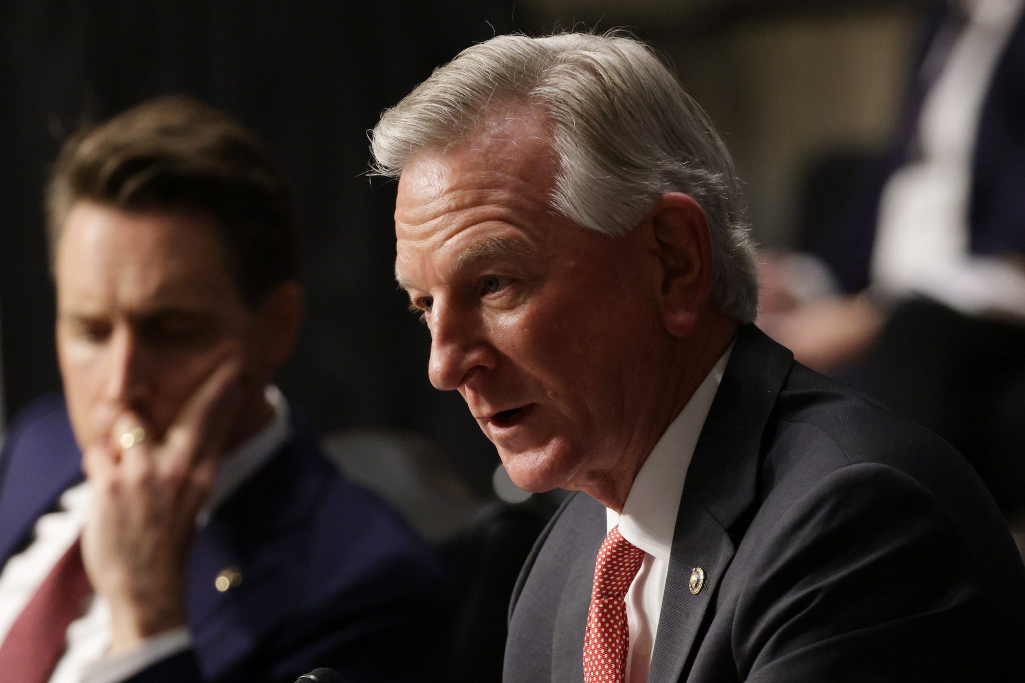 Republican Sen. Tommy Tuberville of Alabama leans forward to make a statement during a committee hearing on Capitol Hill.
