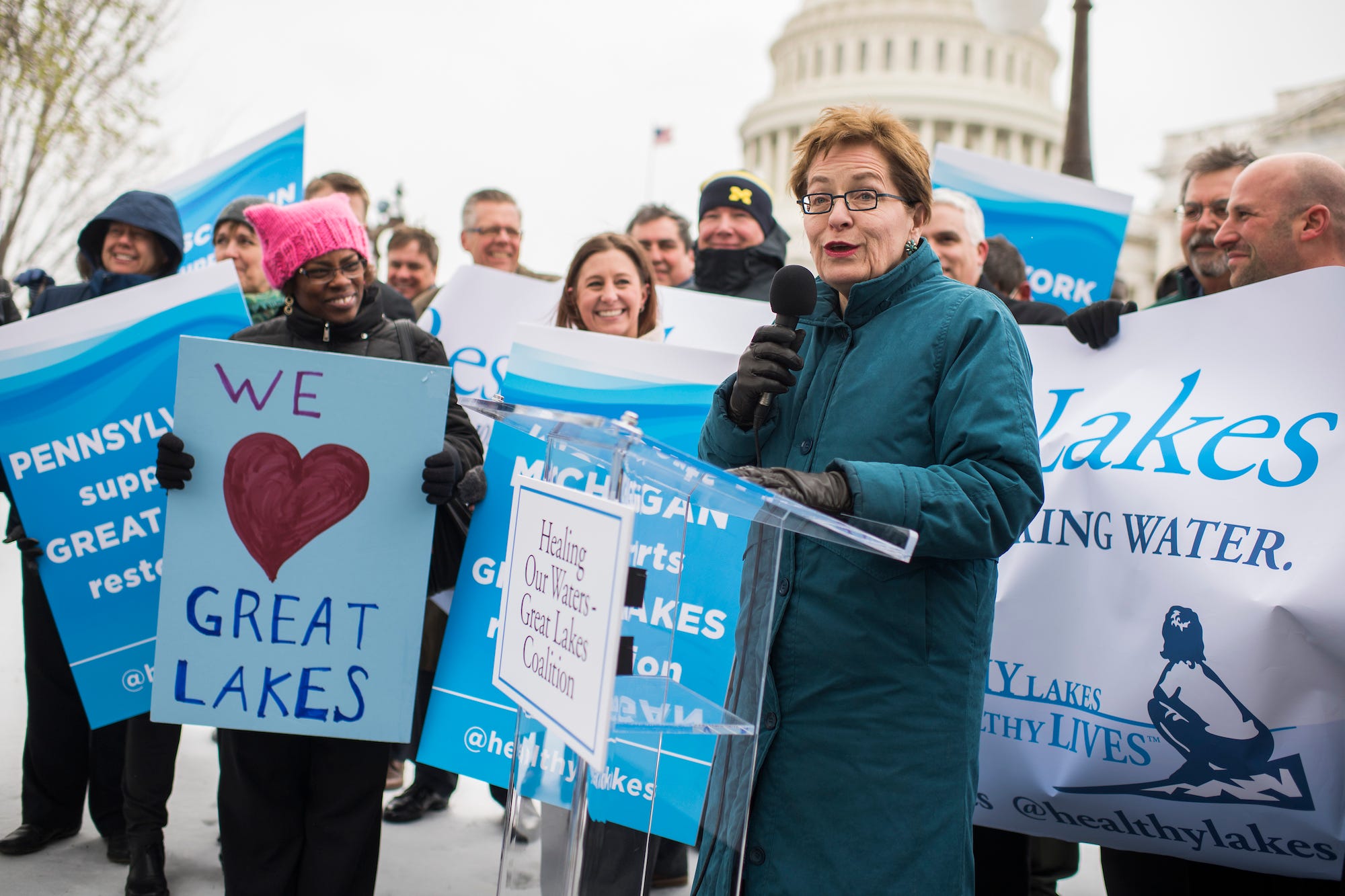 Democratic Rep. Marcy Kaptur of Ohio, wearing a long coat on what looks to be a chilly day in DC, addresses a group of sign-waving environmentalists gathered for a pro-Great Lakes restoration rally on Capitol Hill.