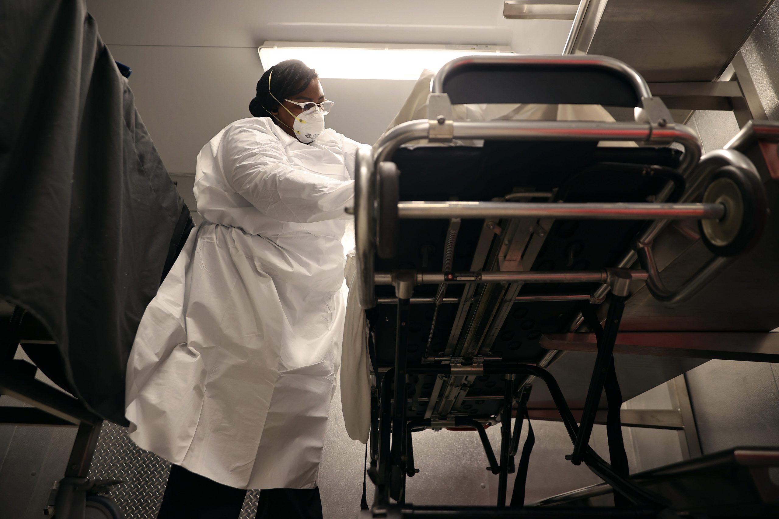 Maryland Cremation Services transporter Morgan Dean-McMillan gently inspects the remains of a coronavirus victim to triple check identification and look for personal belongings in the morgue at Adventist HealthCare White Oak Medical Center May 11, 2020 in Silver Spring, Maryland.