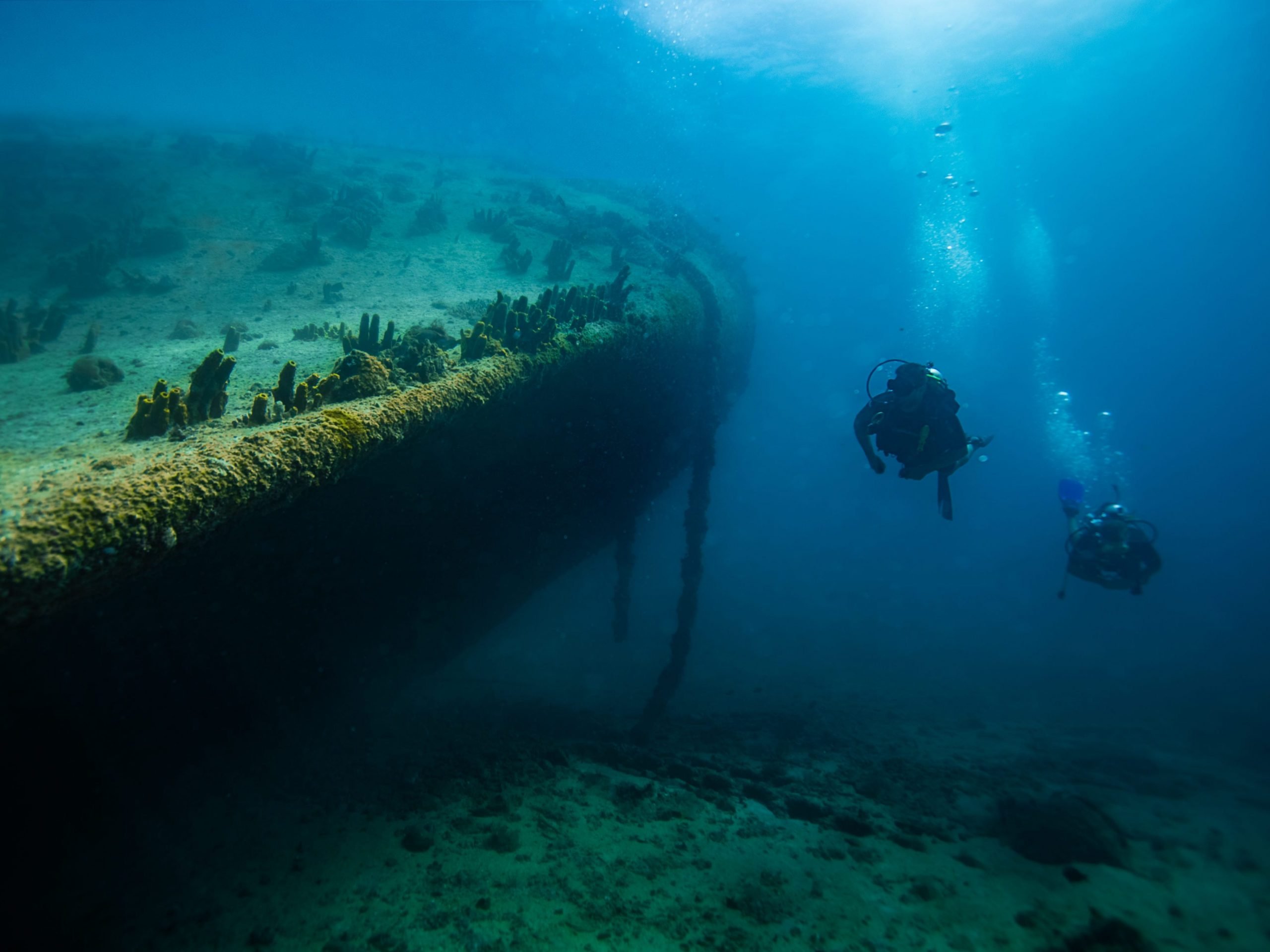 Divers underwater at Antilla shipwreck in Aruba.