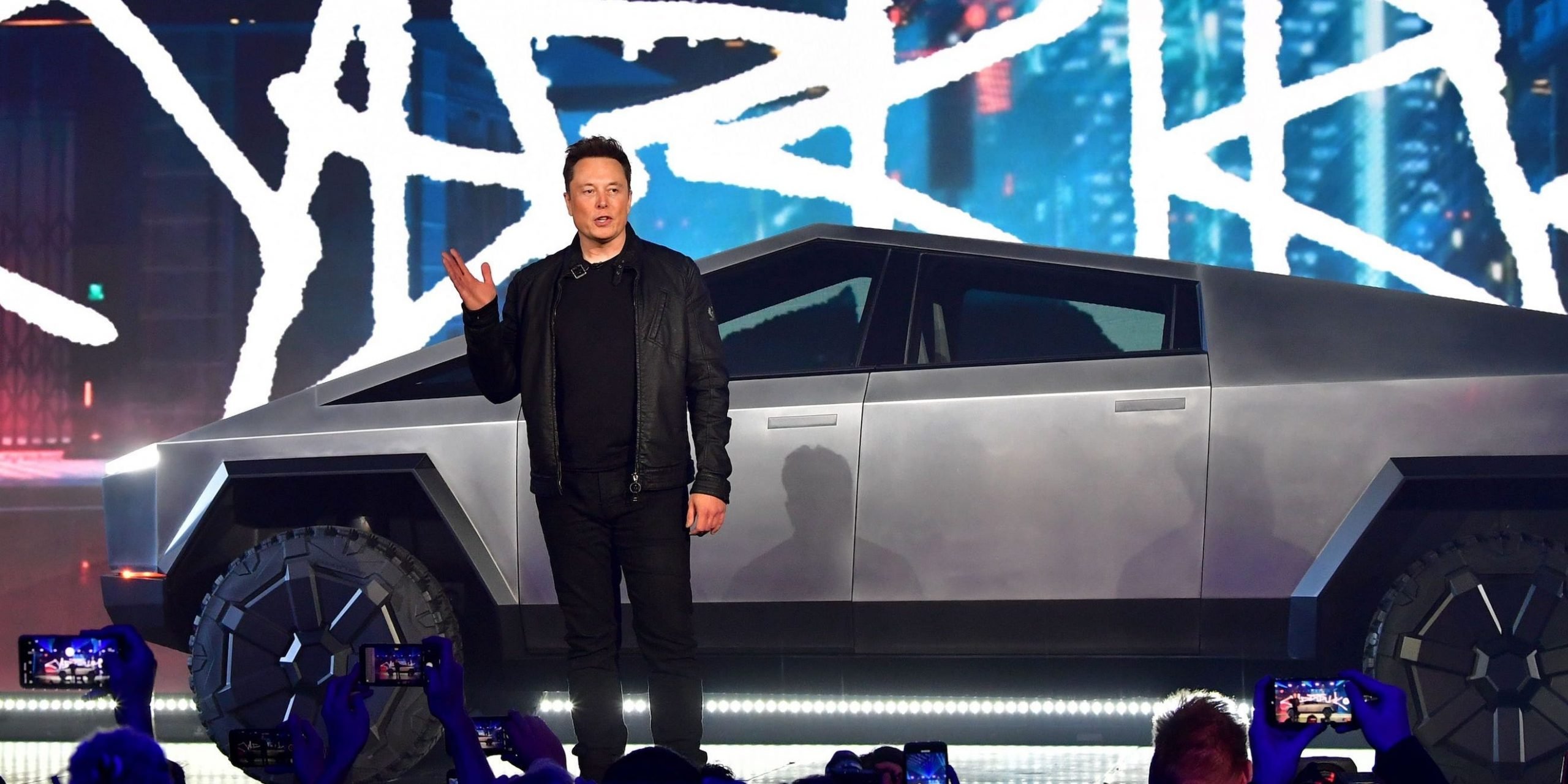 Tesla CEO Elon Musk stands in front of the company's Cybertruck.