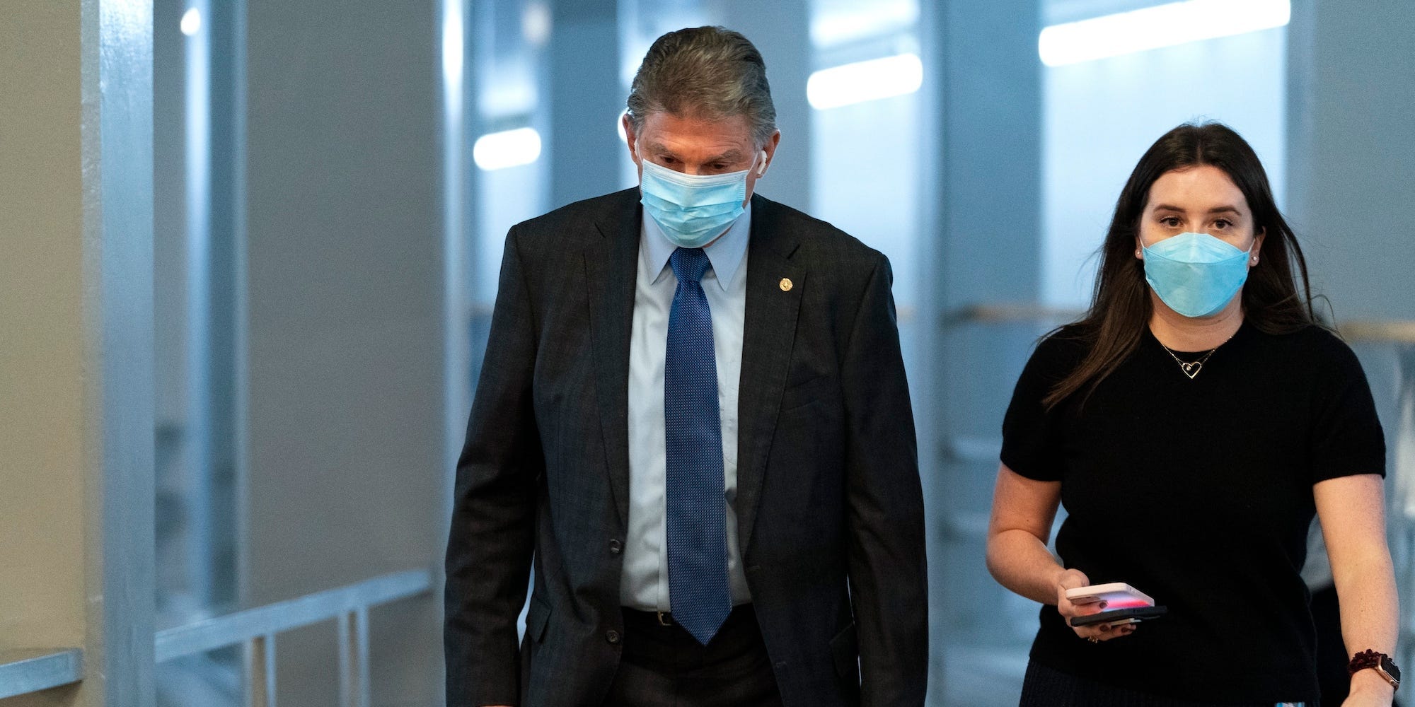 Sen. Joe Manchin, D-W.Va., left, walks to the Senate Chamber for a vote, Wednesday, Dec. 15, 2021, in Washington