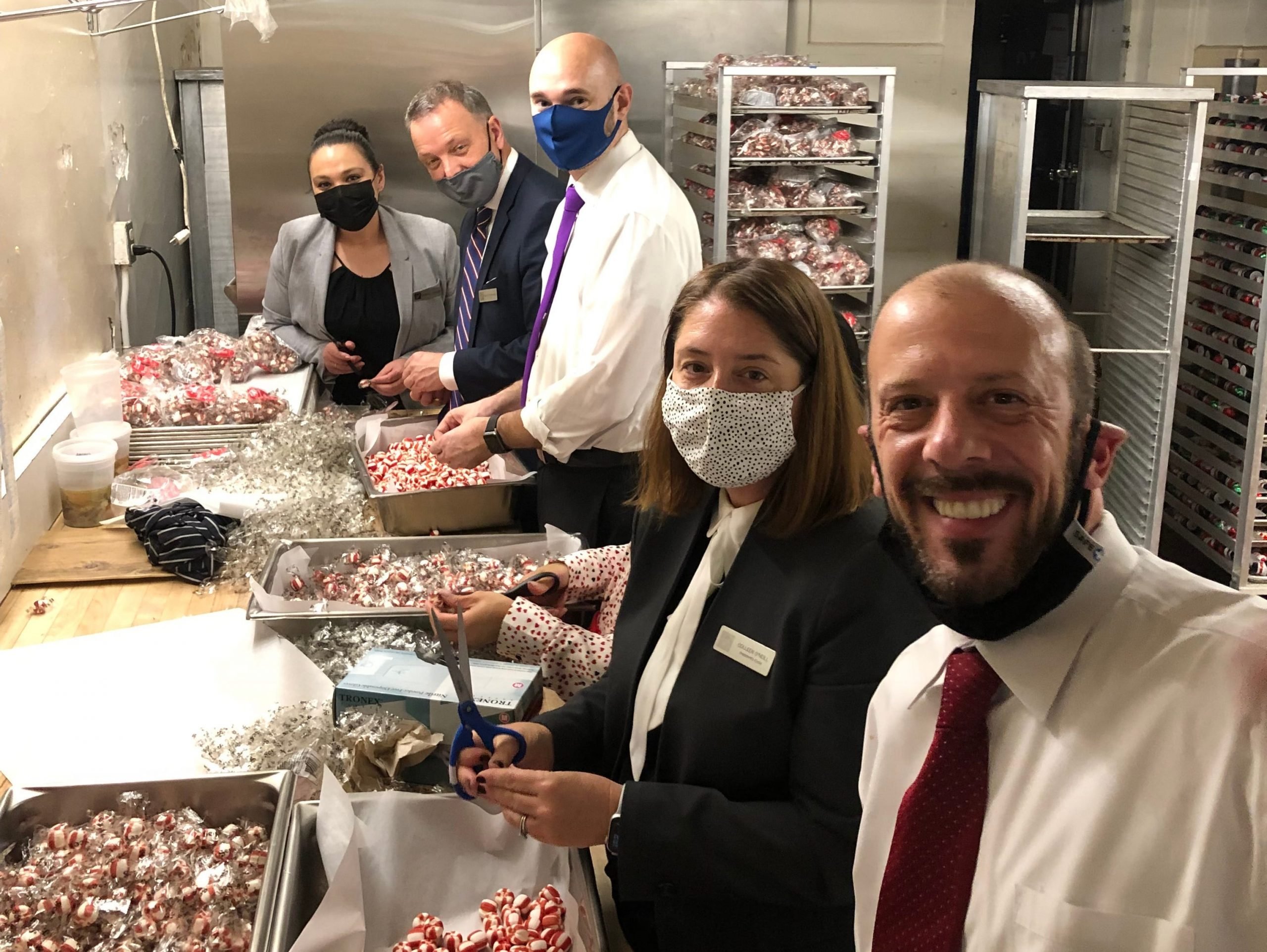 The hotel team unwrapping candy to decorate the gingerbread house. Fairmont San Francisco