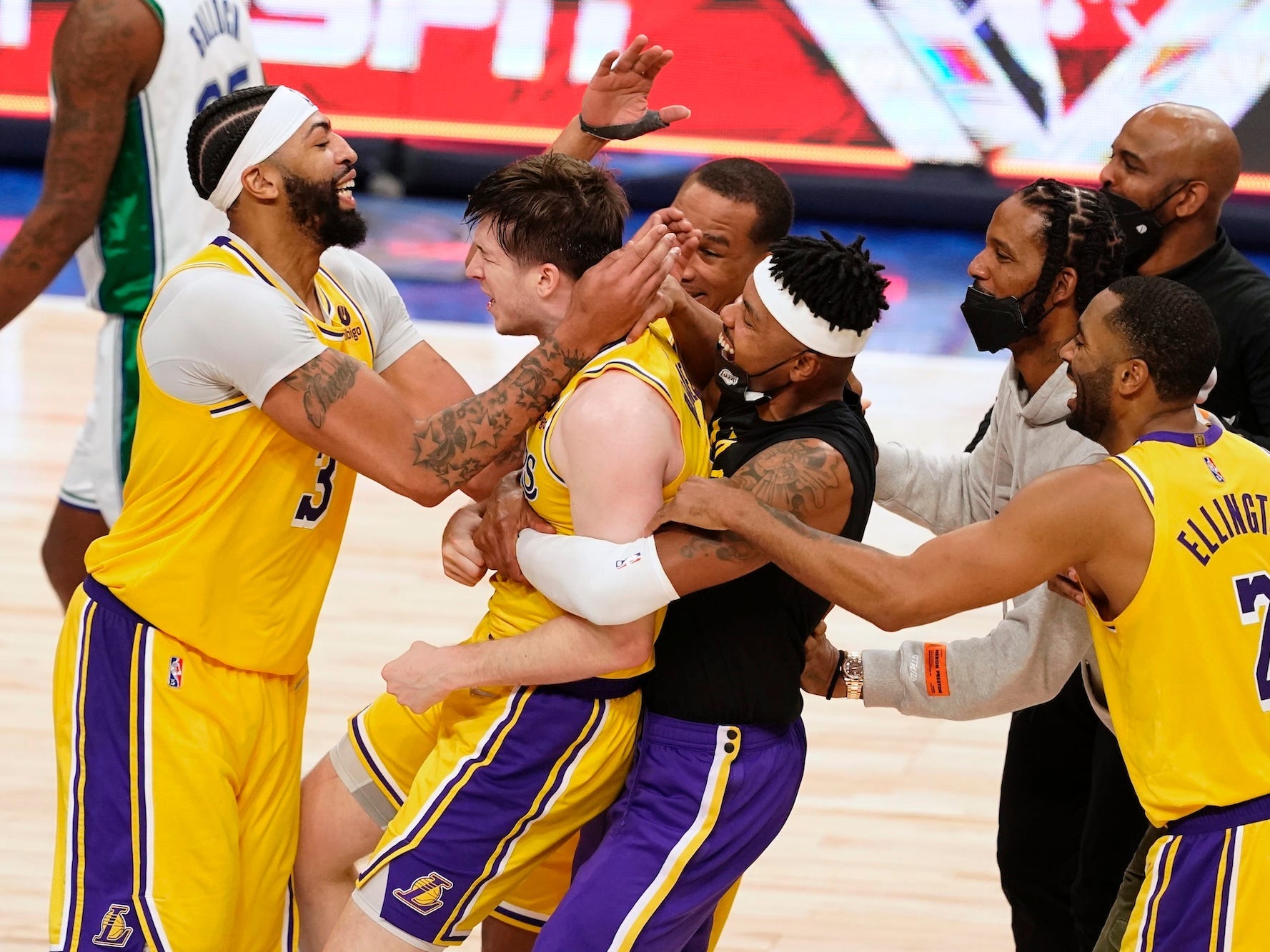 Lakers players hug Austin Reaves.