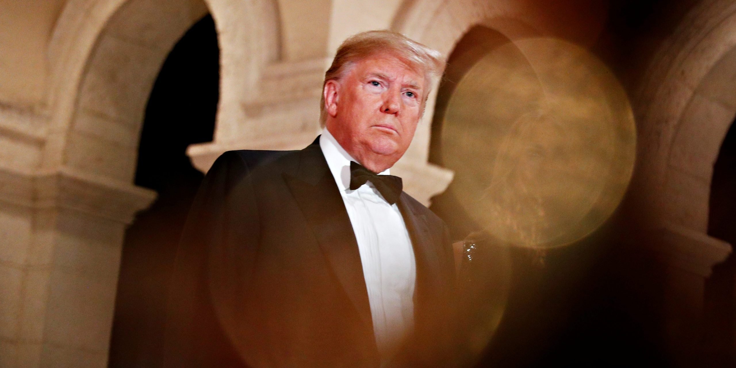 Trump in a black-and-white tuxedo under marble arches at Mar-a-Lago