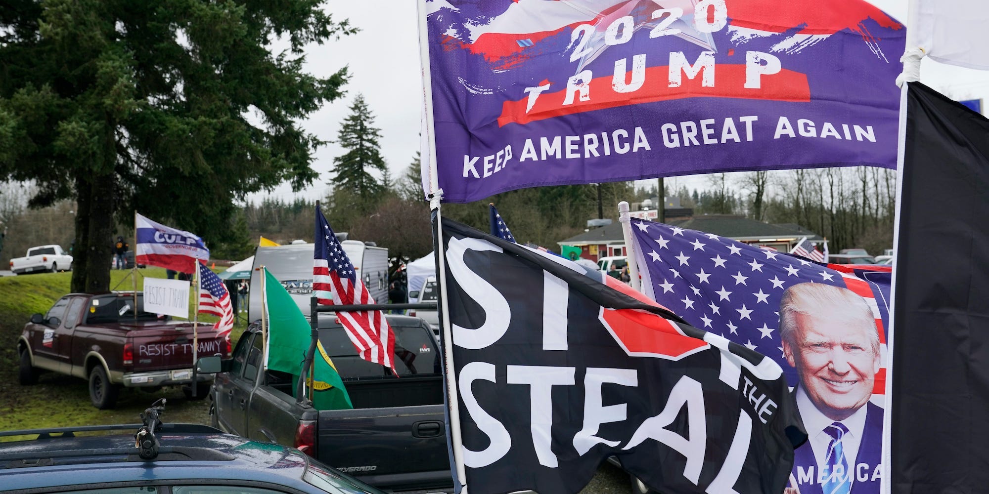 Flags supporting President Donald Trump and one that reads "Stop the Steal" are displayed during a protest rally, Jan. 4, 2021, at the Farm Boy Drive-In restaurant near Olympia, Wash.