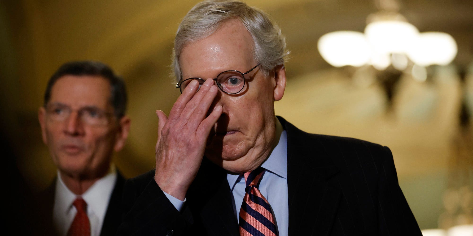 Senate Minority Leader Mitch McConnell pushes his glasses into place before talking to reporters at a press conference at the US Senate on December 14, 2021.