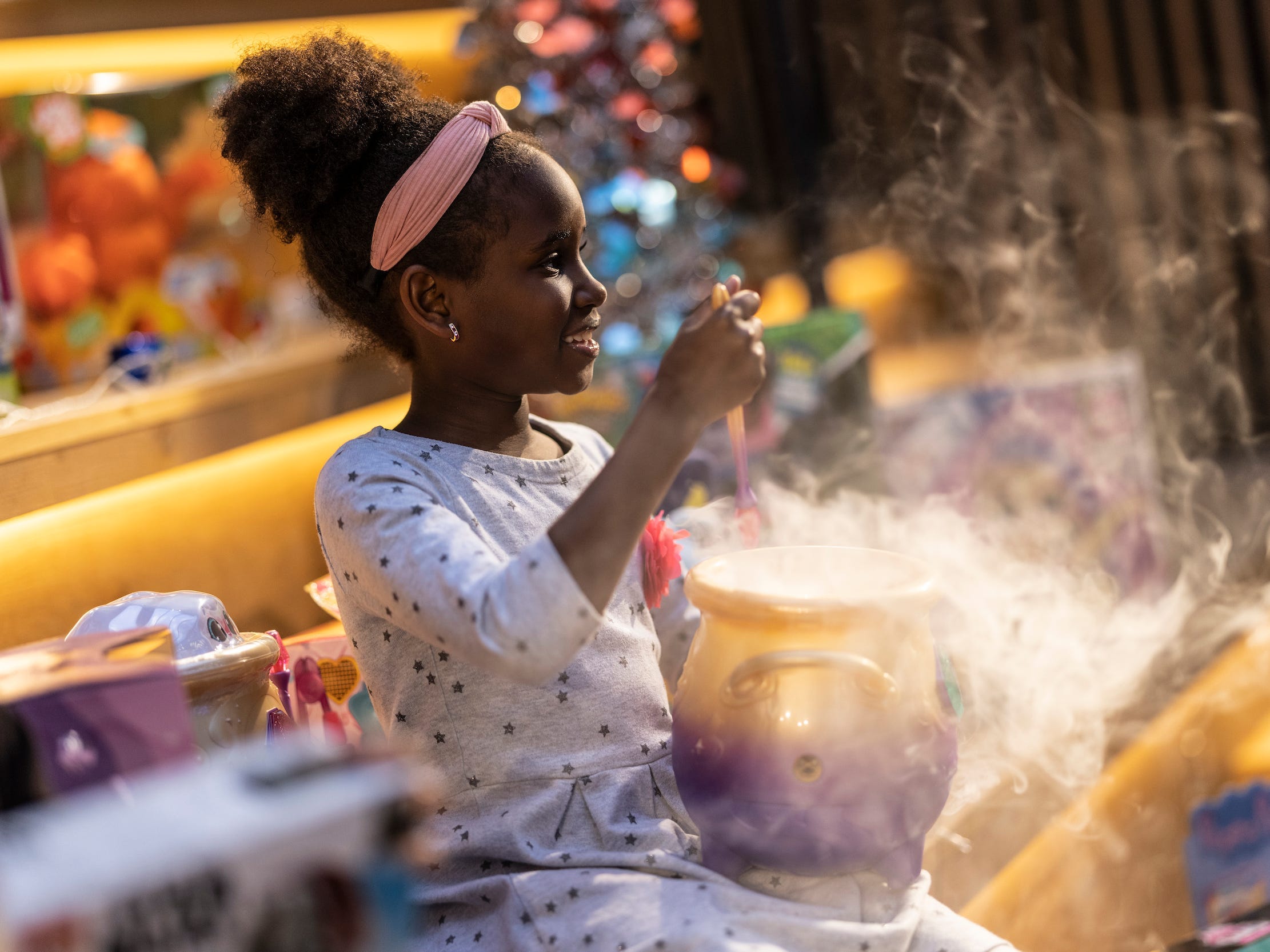 A child plays with a toy Magic Mixies cauldron.