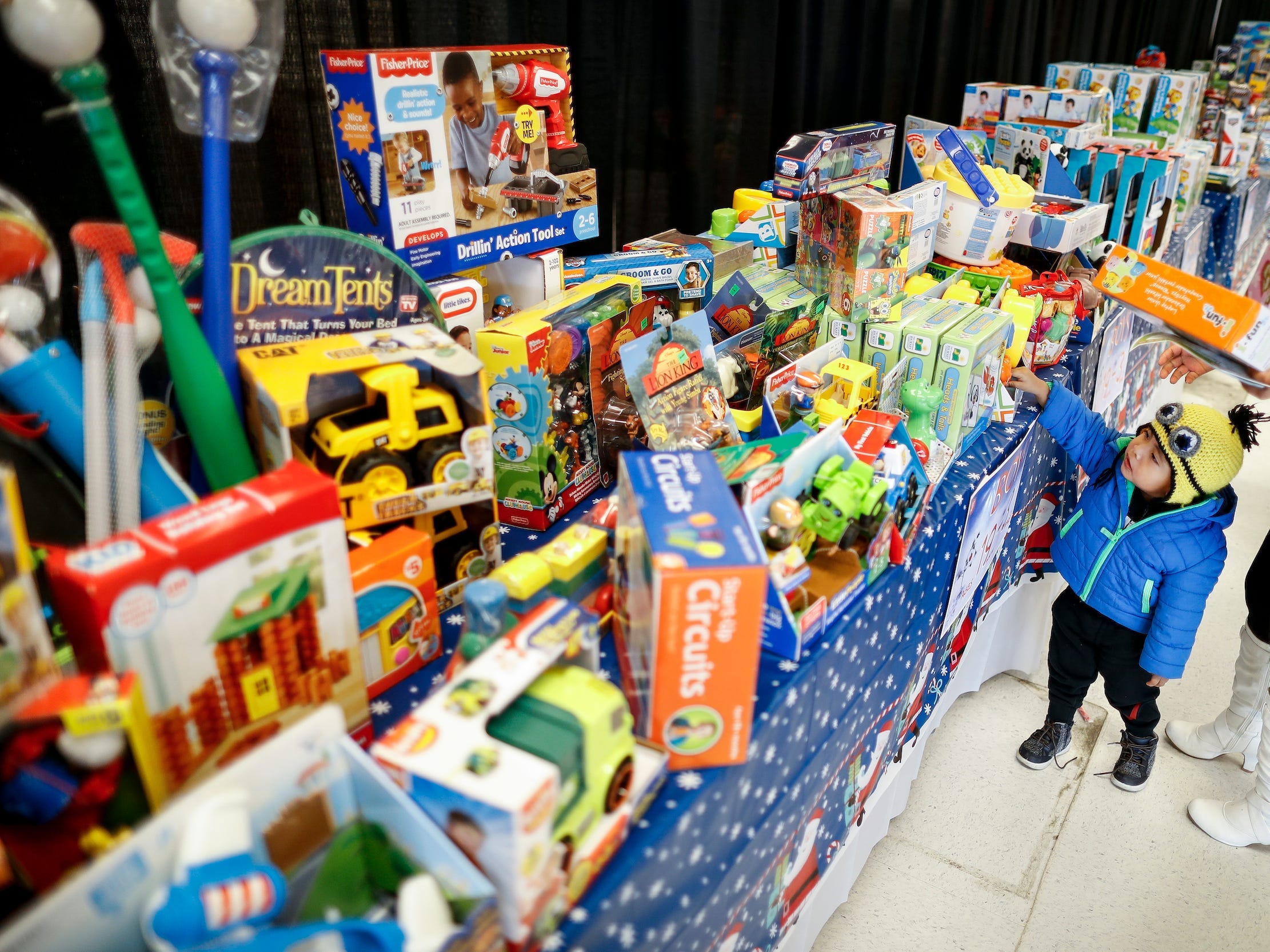 A child examines a shelf full of toys.