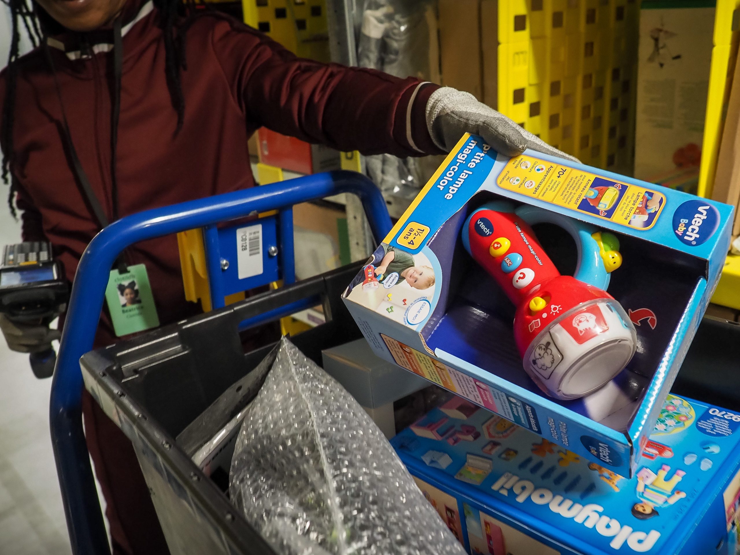 A worker in an Amazon warehouse packages toys for shipping.