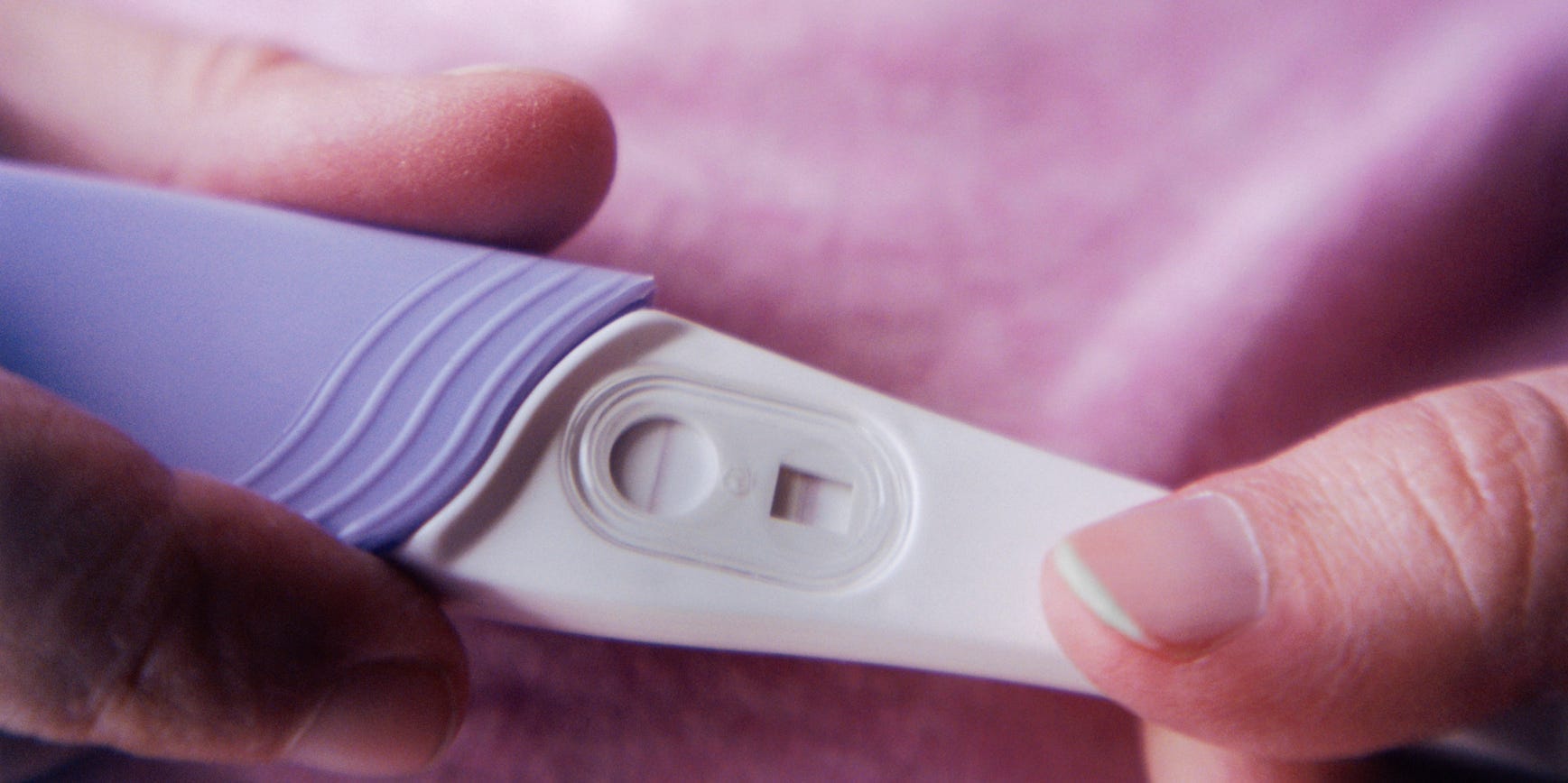 A person holding a pregnancy test.