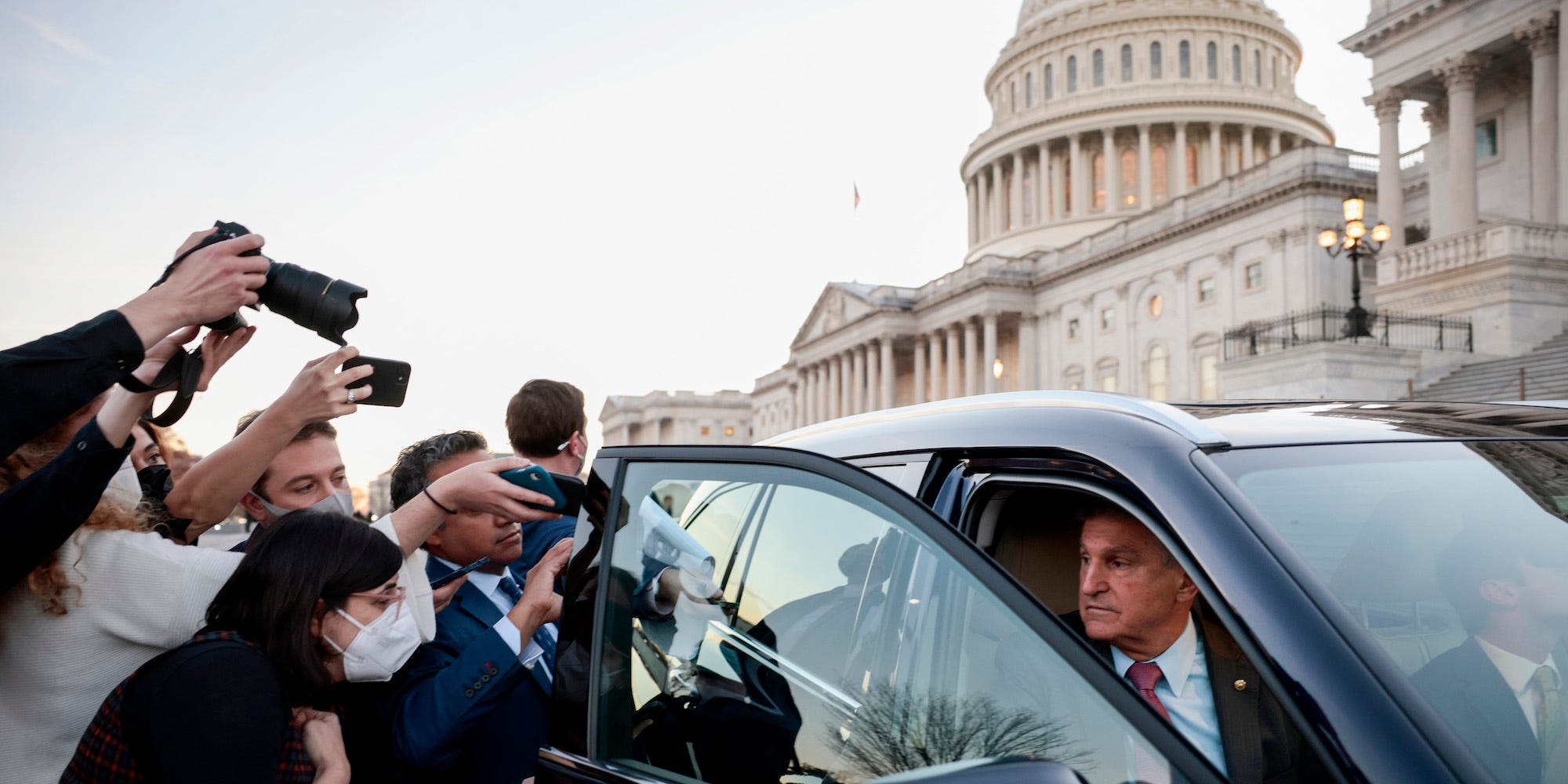 Democratic Sen. Joe Manchin of West Virginia is followed to his car by reporters after a vote at the US Capitol on December 14, 2021.