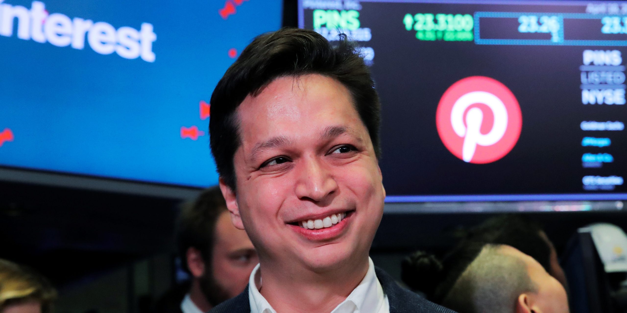 A headshot of Pinterest CEO Ben Silbermann on the stock exchange floor in front of a sign with the pinterest logo