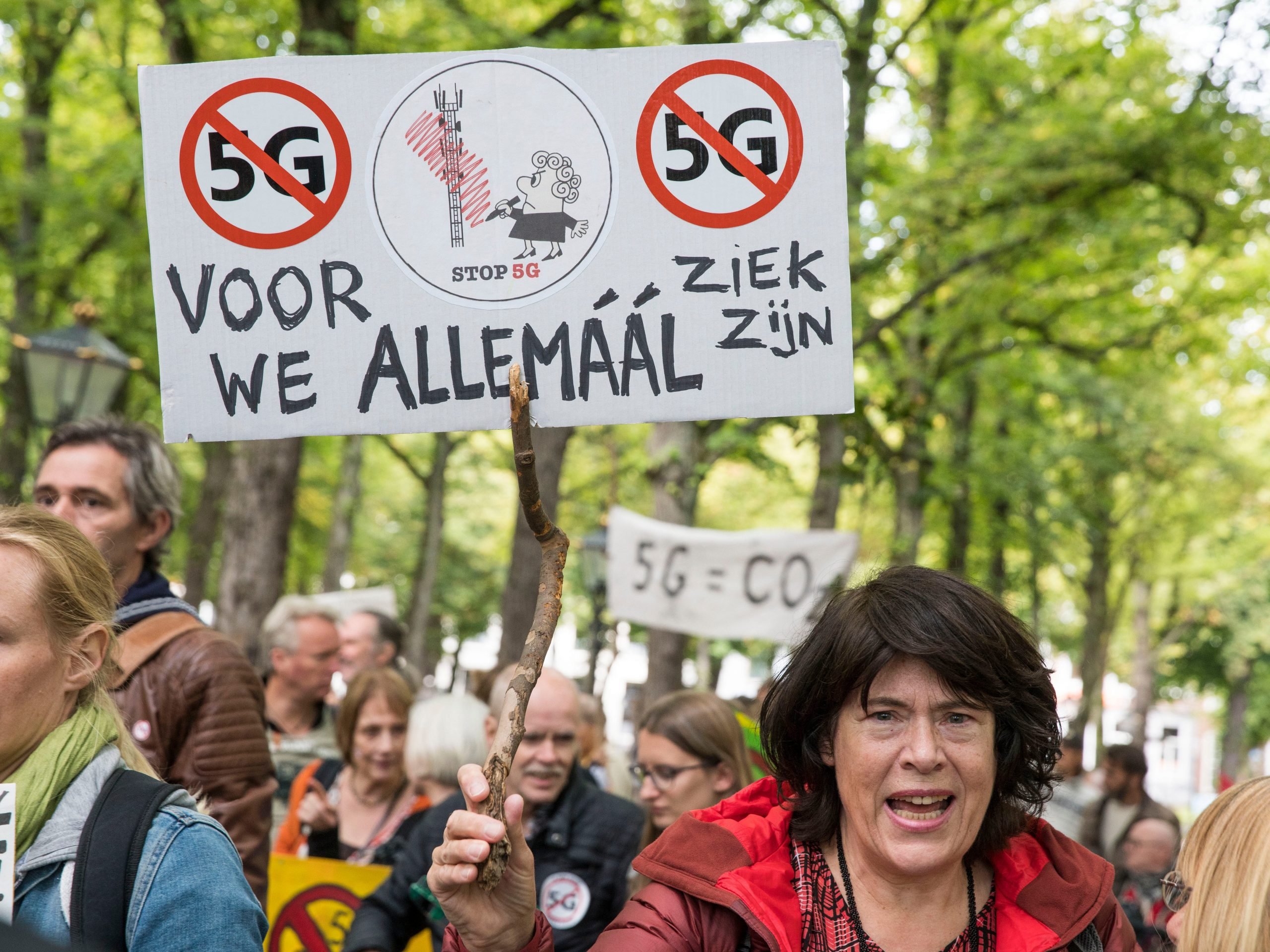 A protester holds a sign reading 'Stop 5G, before we're all ill' in a march against 5G technology in The Hague, Netherlands.