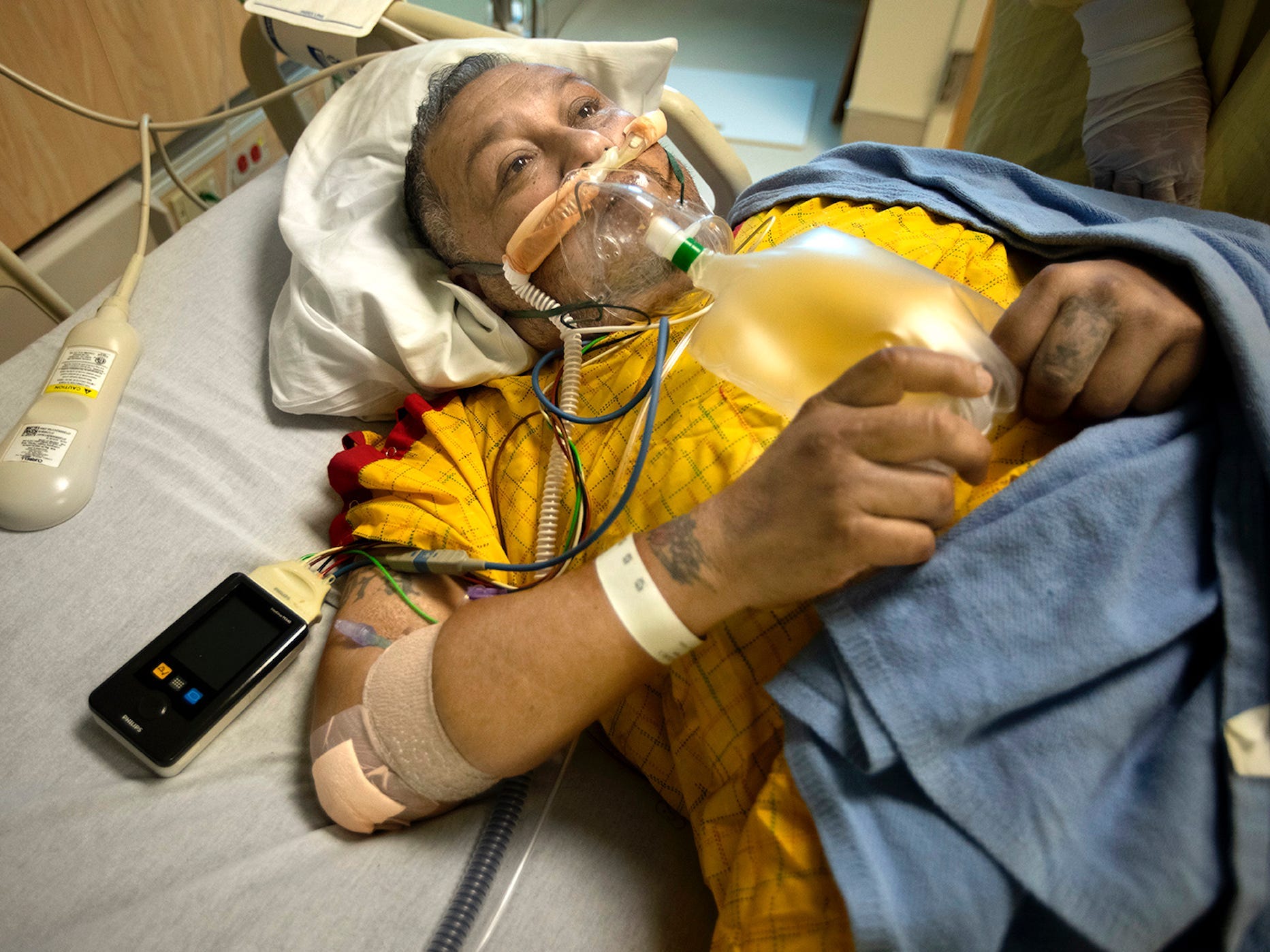 man on ventilator for covid, looking up in his hospital bed