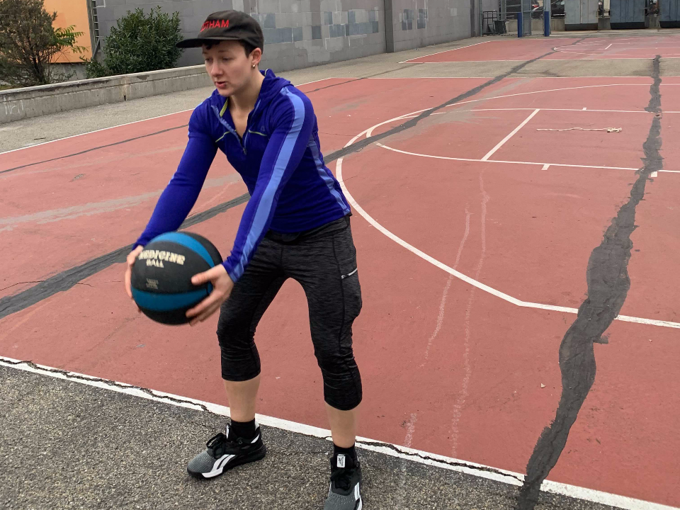 fitness reporter getting ready to toss a medicine ball