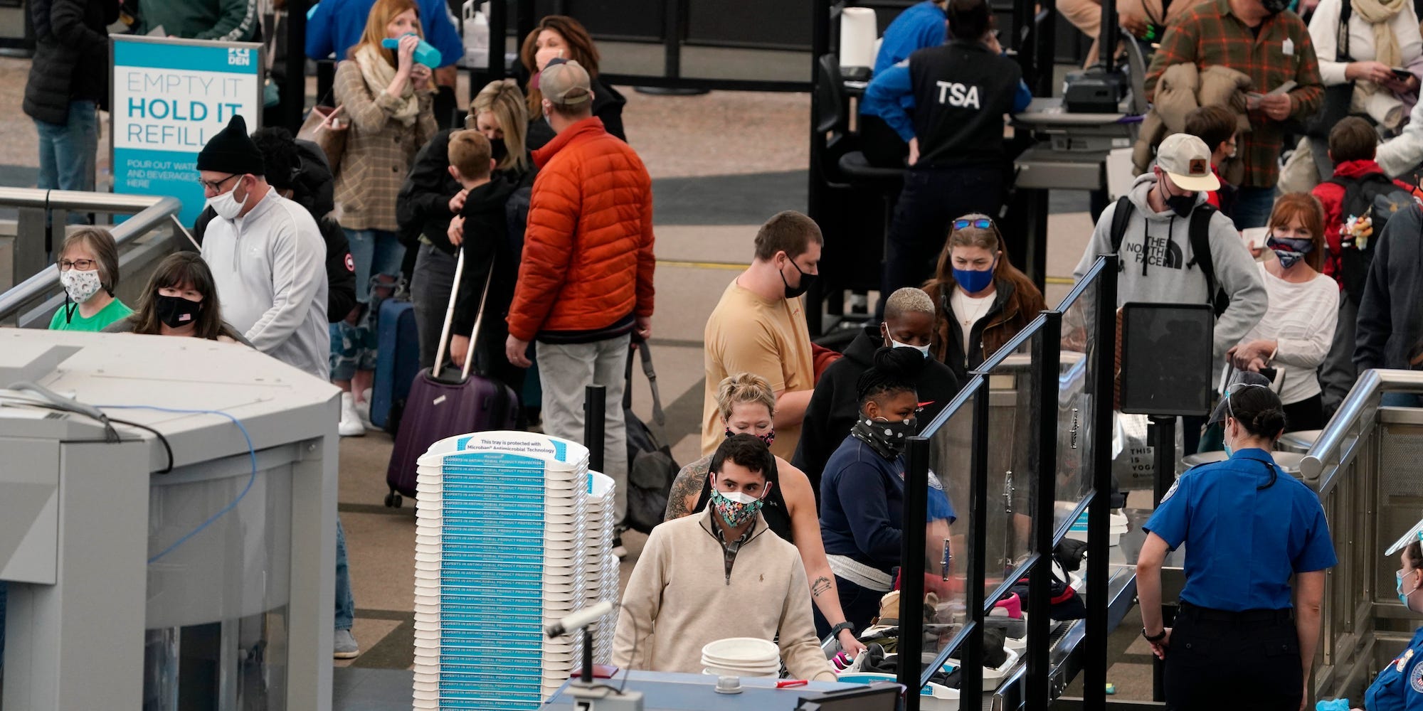 Airline passengers standing in line to go through security.