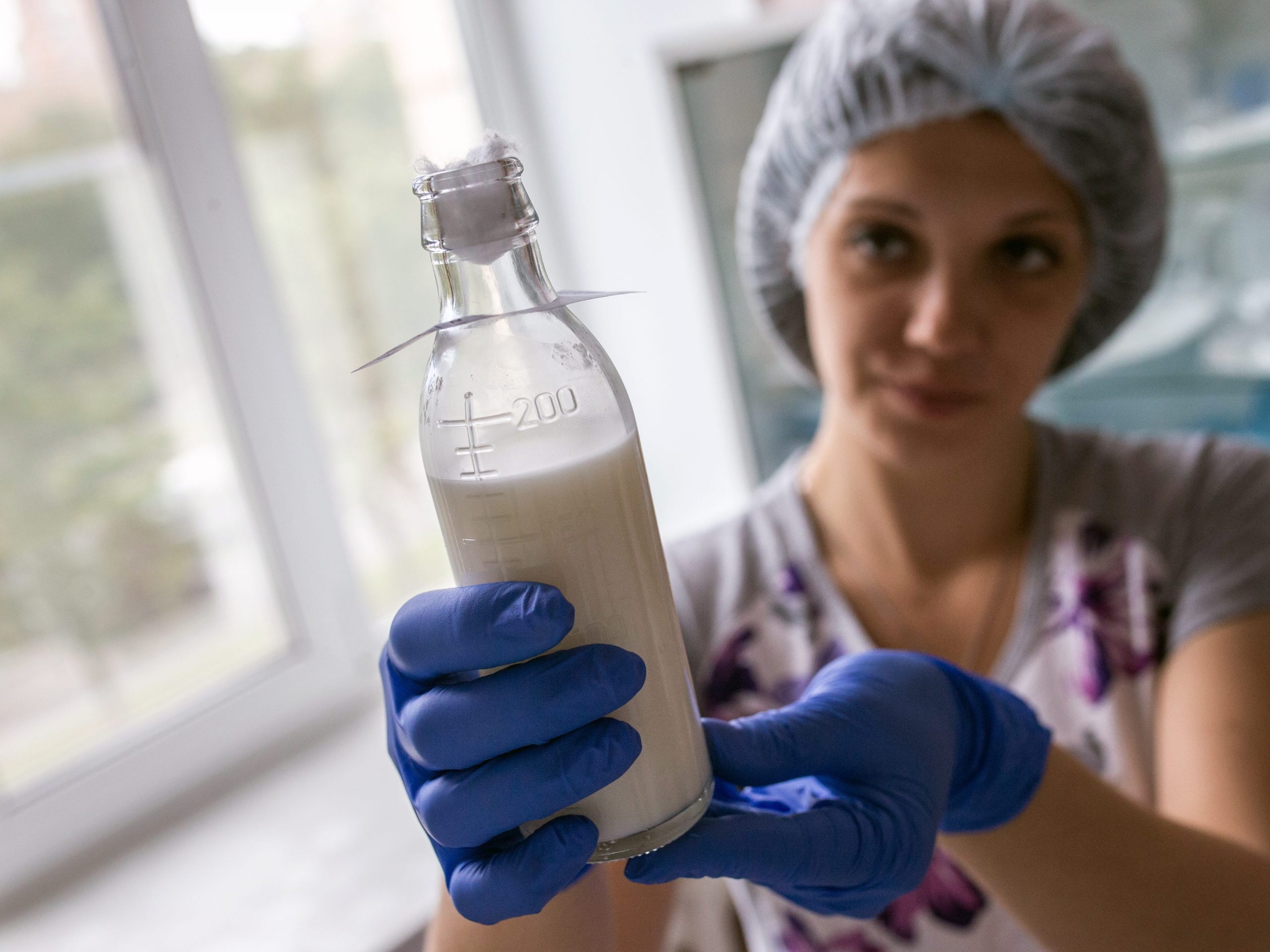 nurse holding bottle of breast milk