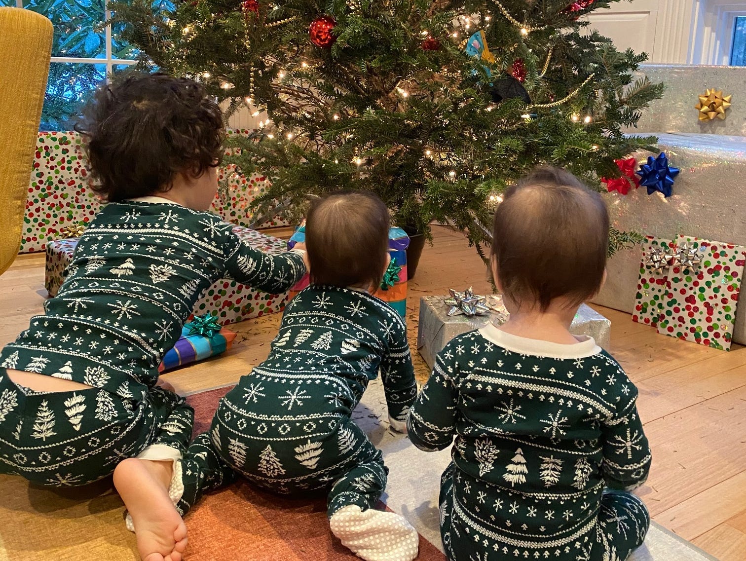 Kids looking at a Christmas tree in matching oufits