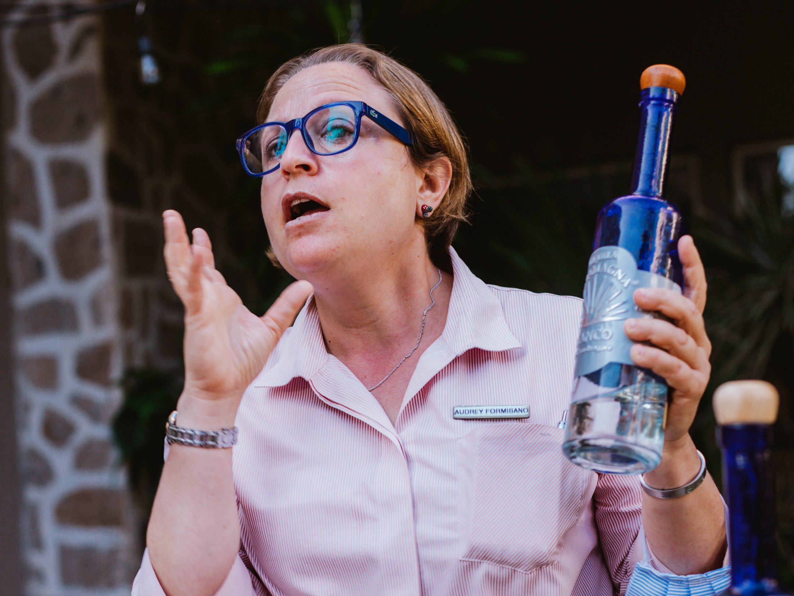 woman in a pink shirt holding tequila