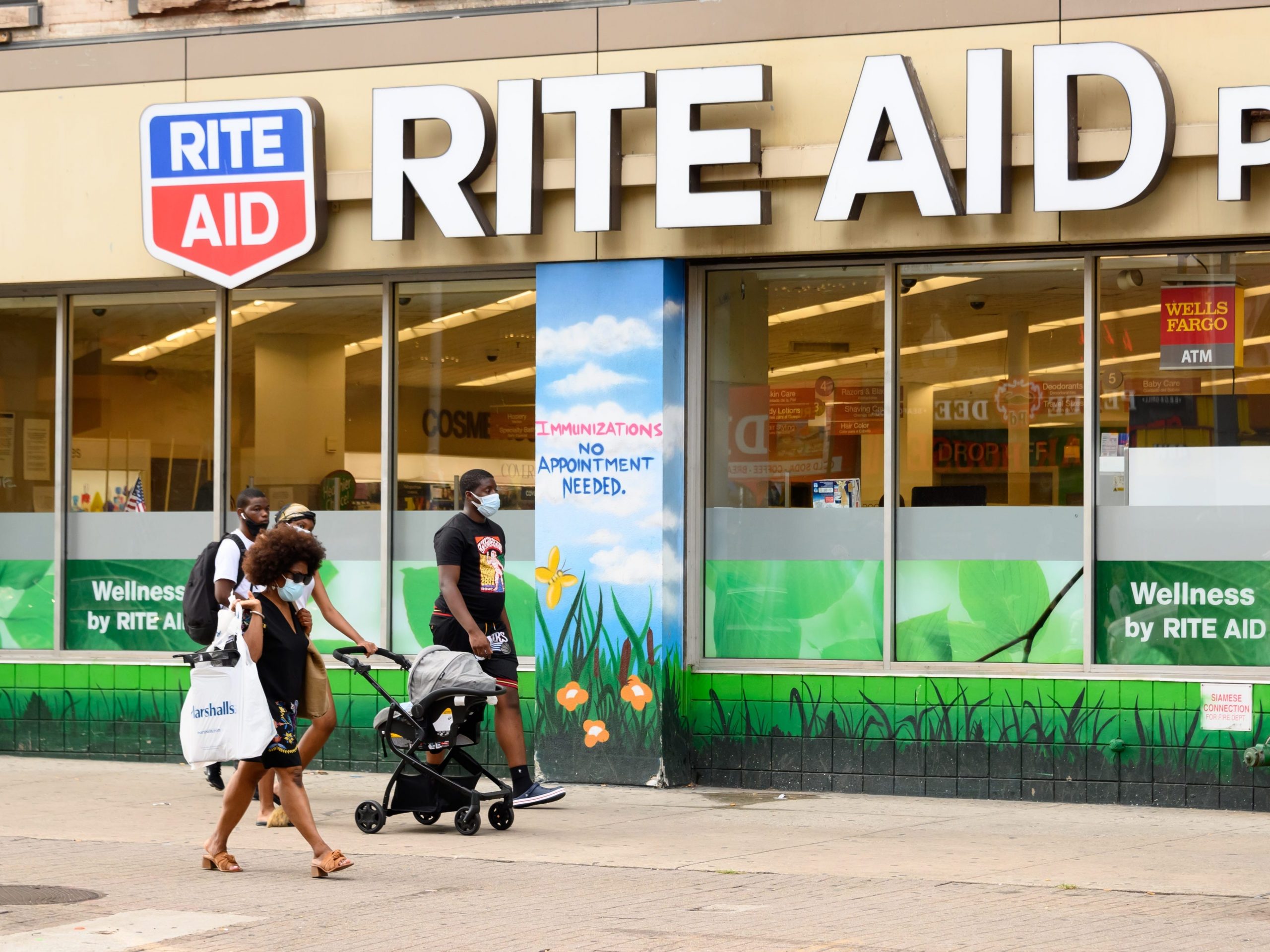 People wear protective face masks outside Rite Aid in Harlem
